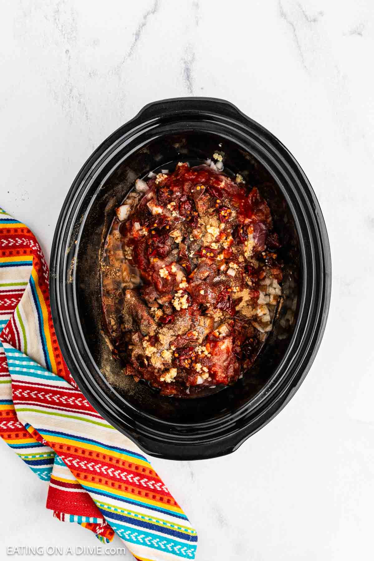 Ingredients are added to the slow cooker.