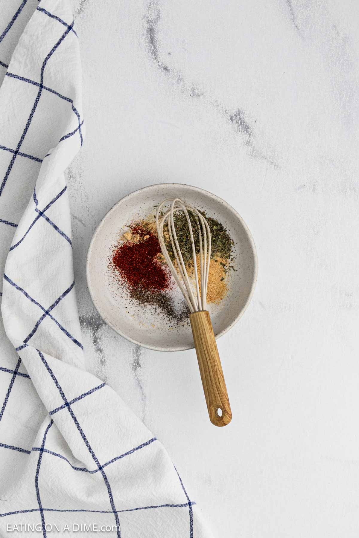 Spices placed in a bowl with a whisk on top of the bowl.