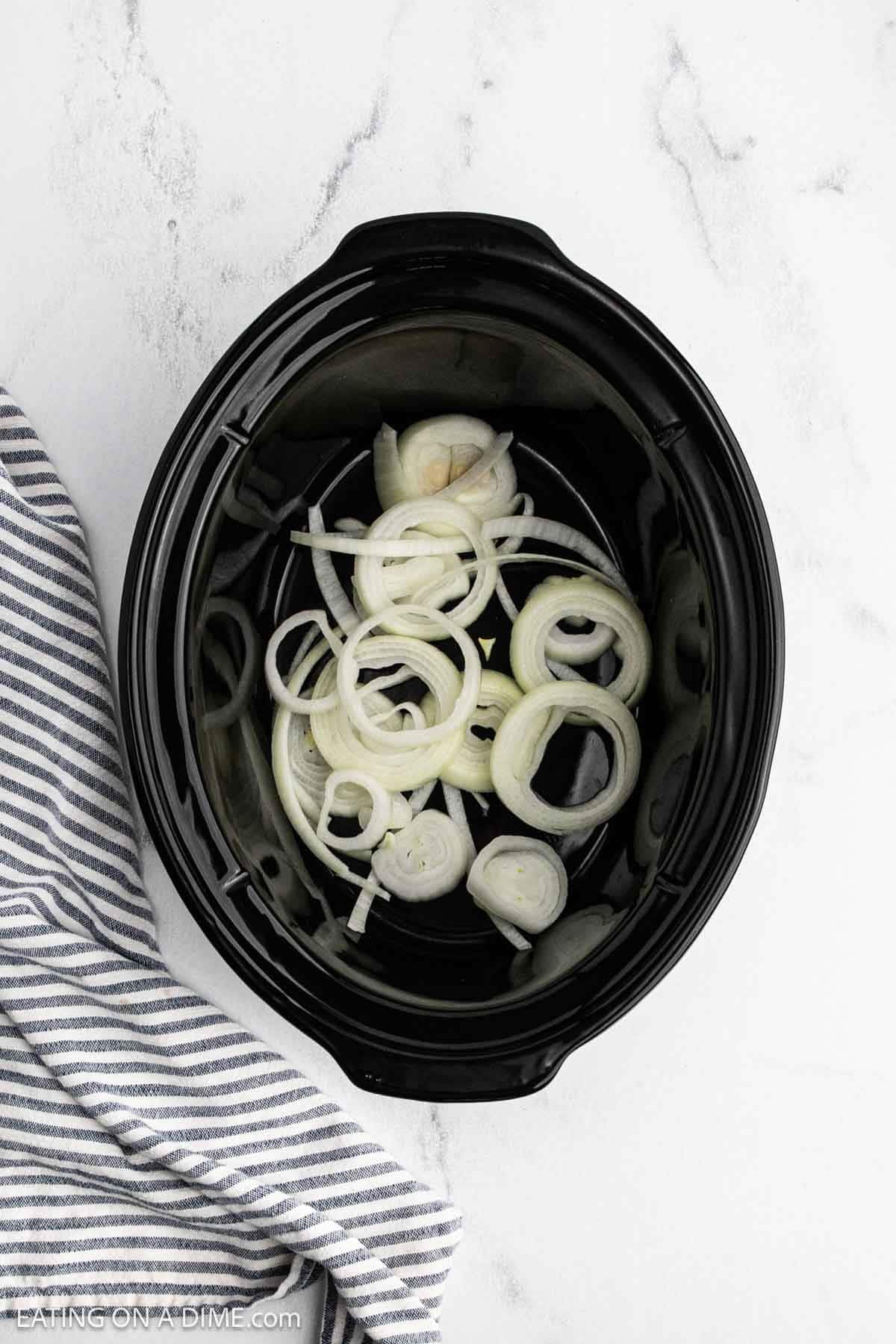 Slice onions in the crock pot.