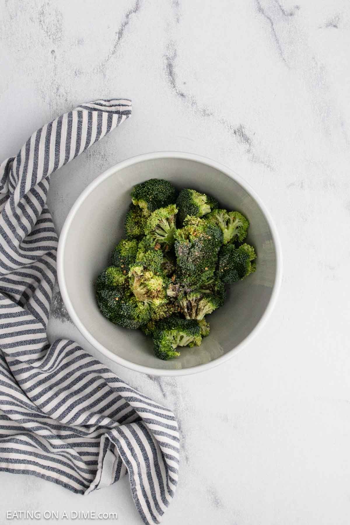 Fresh broccoli mixed with simple seasoning in a bowl.