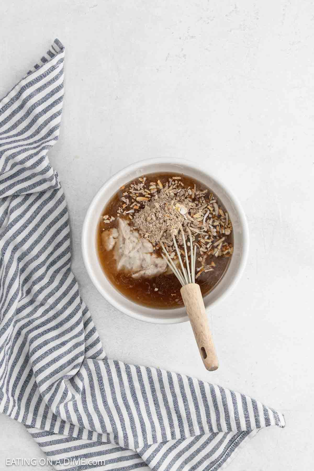 Combining the gravy ingredients in a bowl with a whisk.