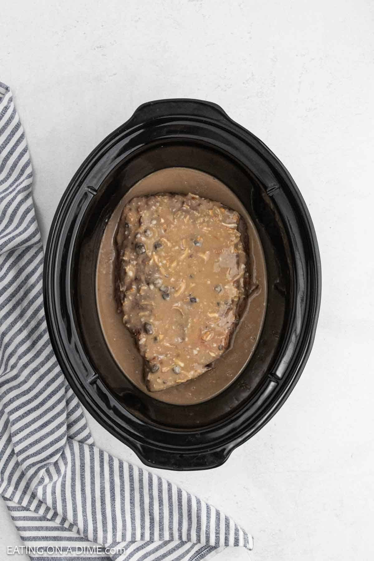 Gravy mixture poured over the roast in the slow cooker.