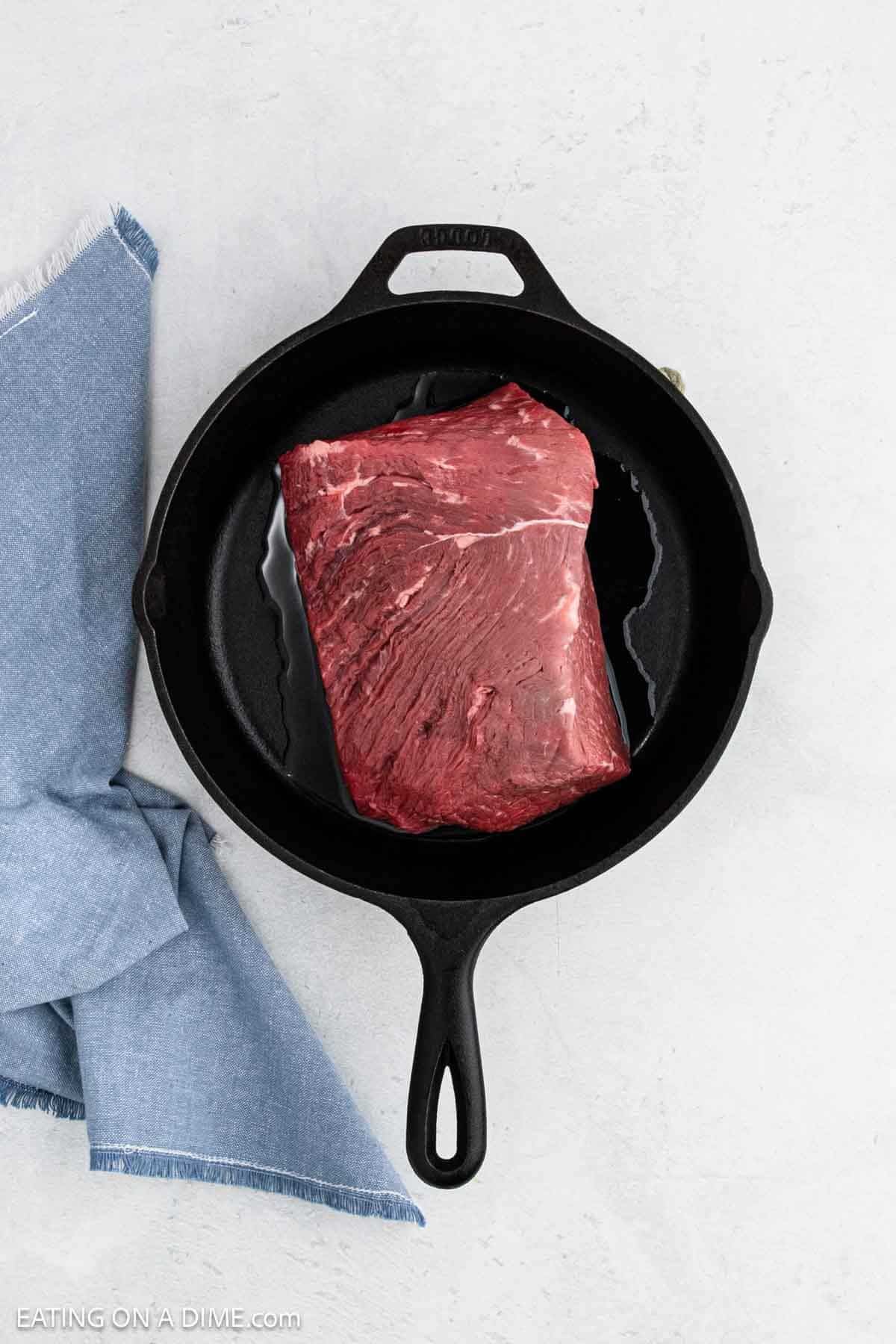 Placing the roast in a cast iron skillet.