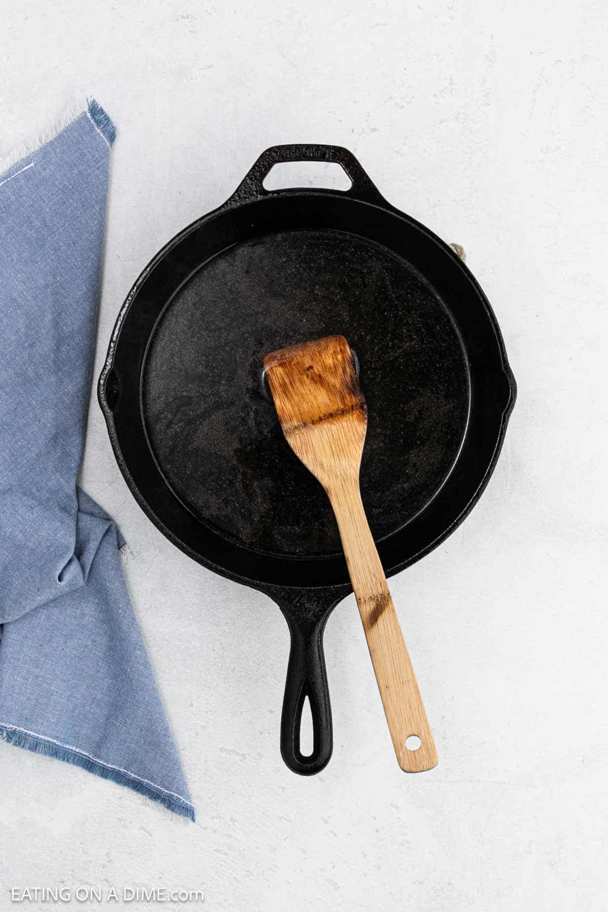 Oil in a cast iron skillet with a wooden spoon.