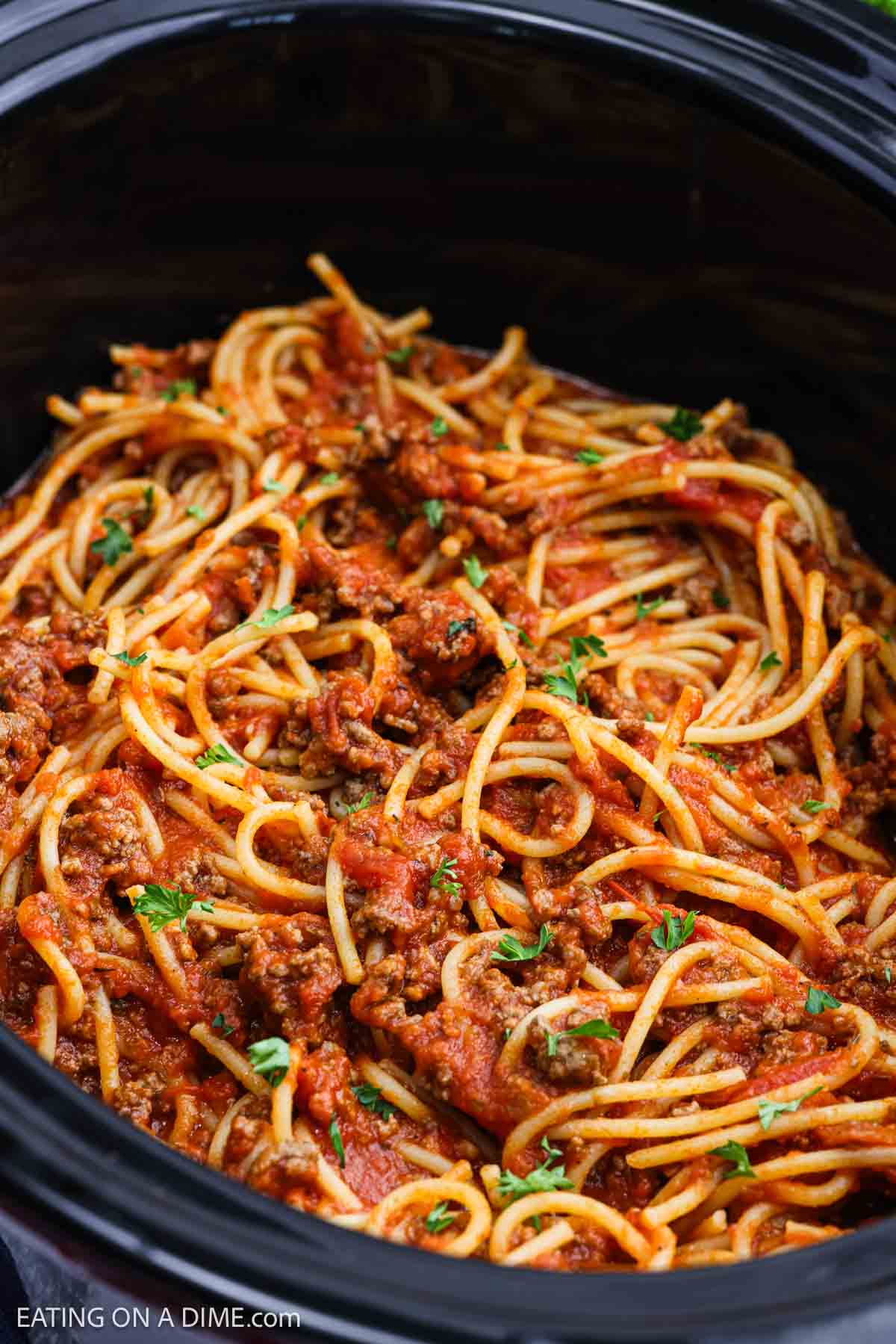 Meat sauce mixed with spaghetti noodles in the crock pot.