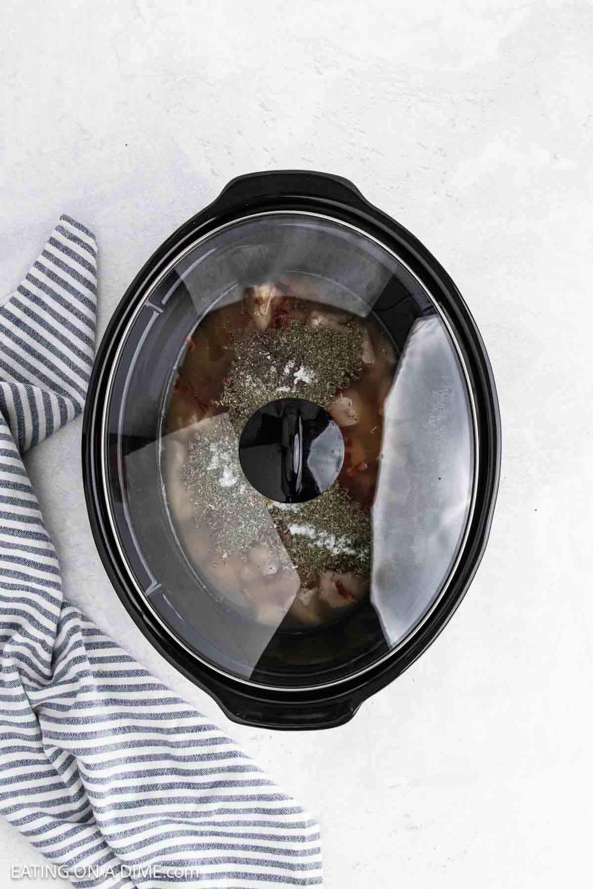 Ingredients added to the slow cooker with the lid on the top.