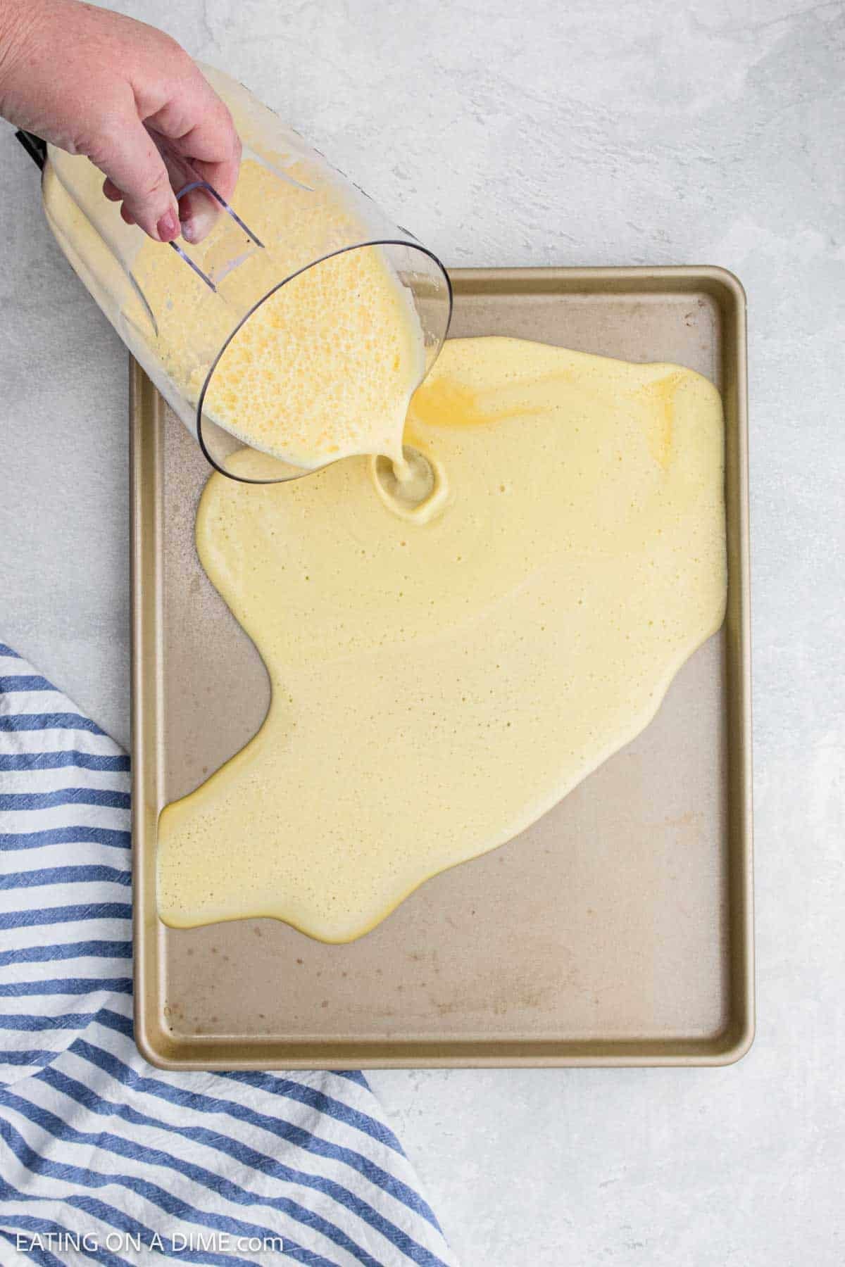 Pouring the egg mixture into the sheet pan.