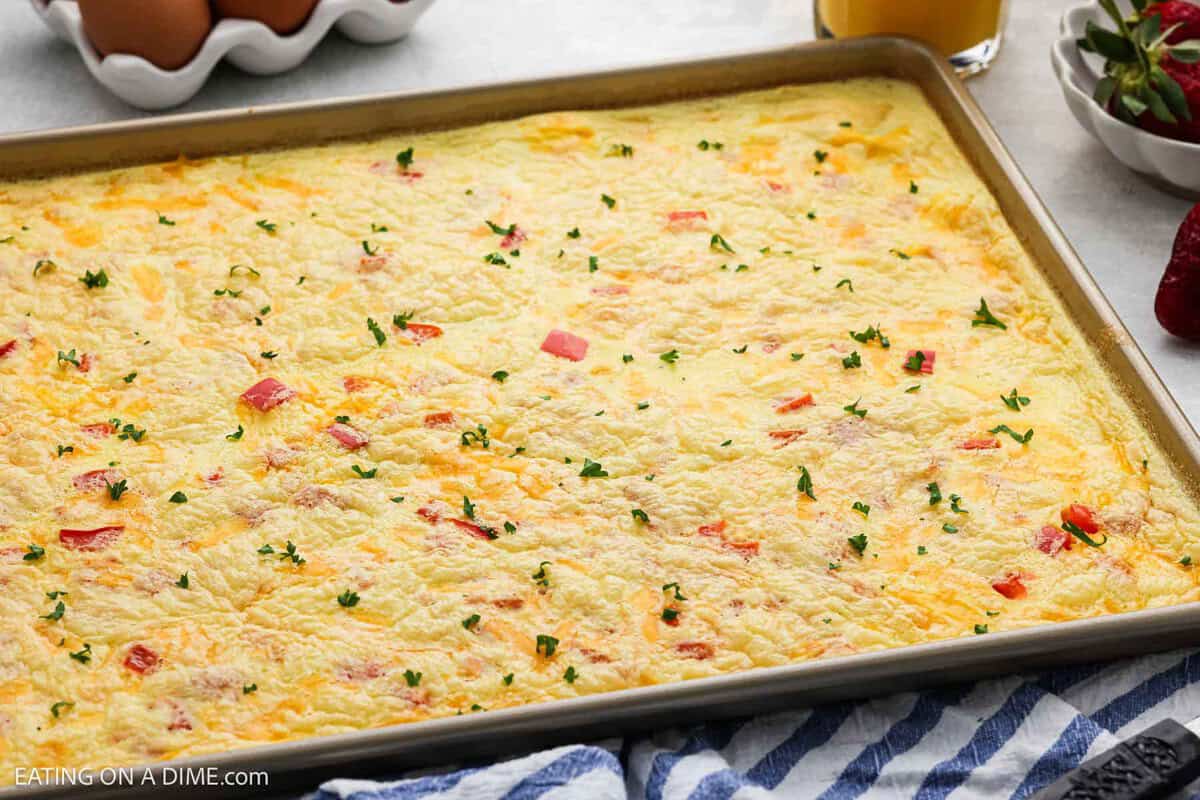 Sheet pan eggs in a pan topped with fresh herbs.