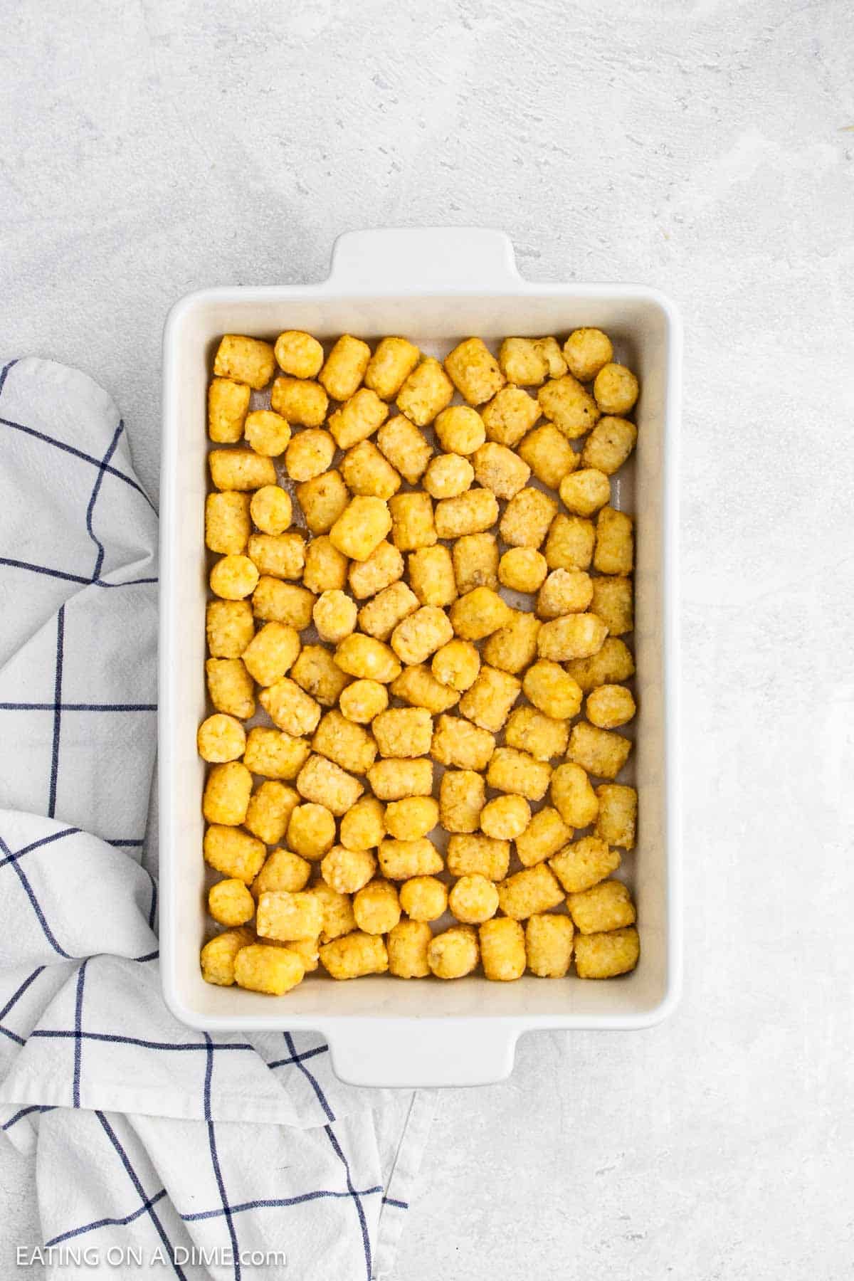 Tater tot spread in a white baking dish.
