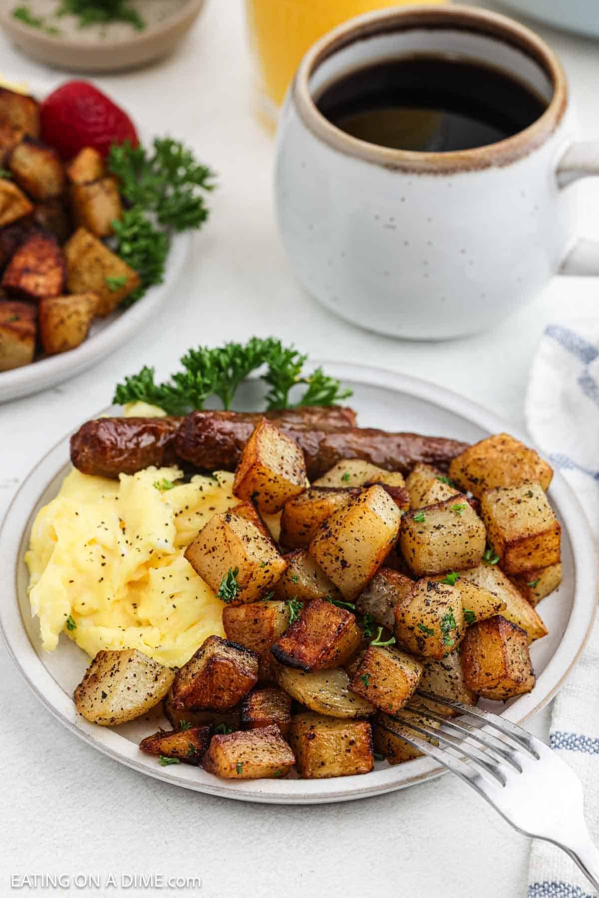 Serving of golden cooked potatoes on a plate with scrambled eggs and sausage links.