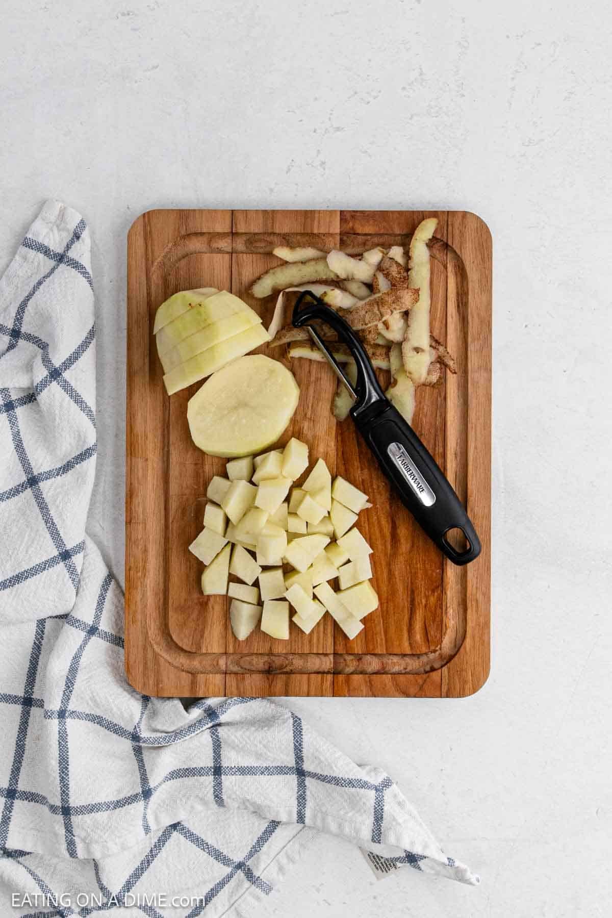 Dicing and peeling russet potatoes on a cutting board.