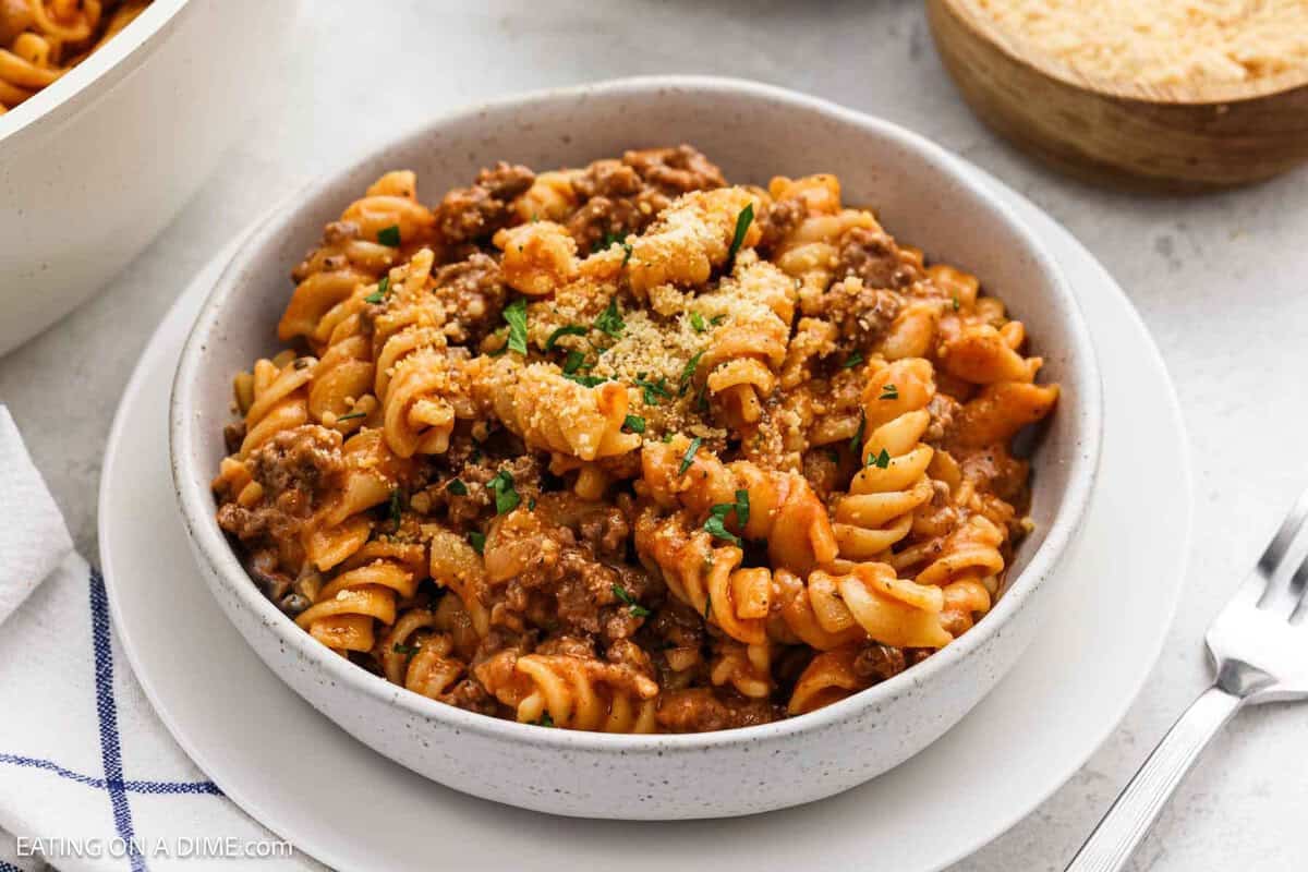 Ground Beef Pasta in a bowl topped with parmesan cheese and parsley.