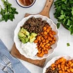 Ground, diced sweet potatoes, avocado, and cottage cheese placed in a bowl.