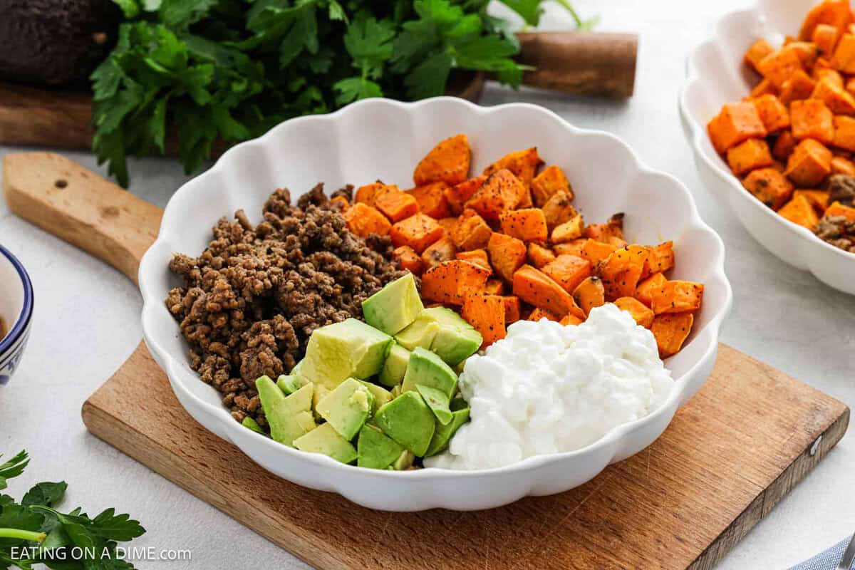 Ground Beef Sweet Potato Bowl sitting on a wooden platter.