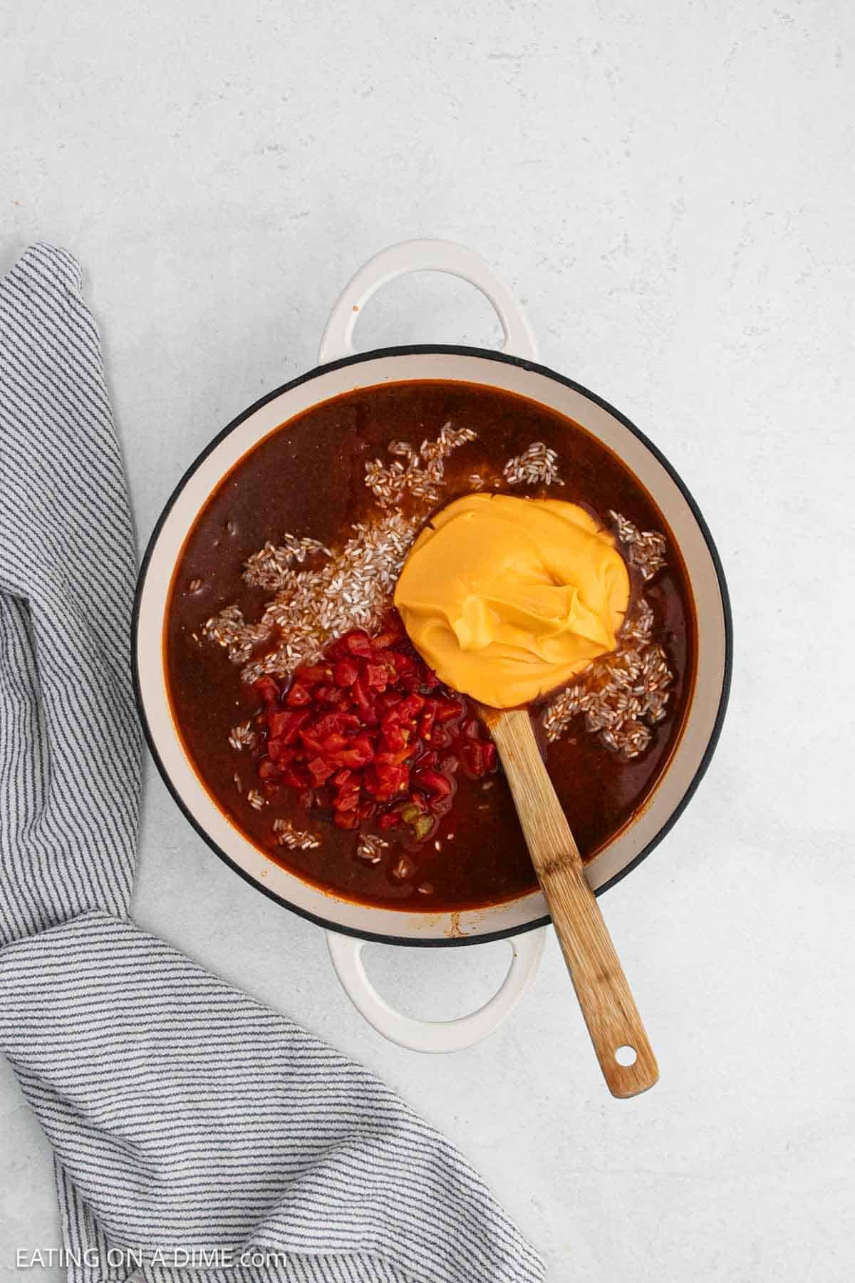 Rice, cheese sauce, and diced tomatoes added to the large pot with the broth mixture.