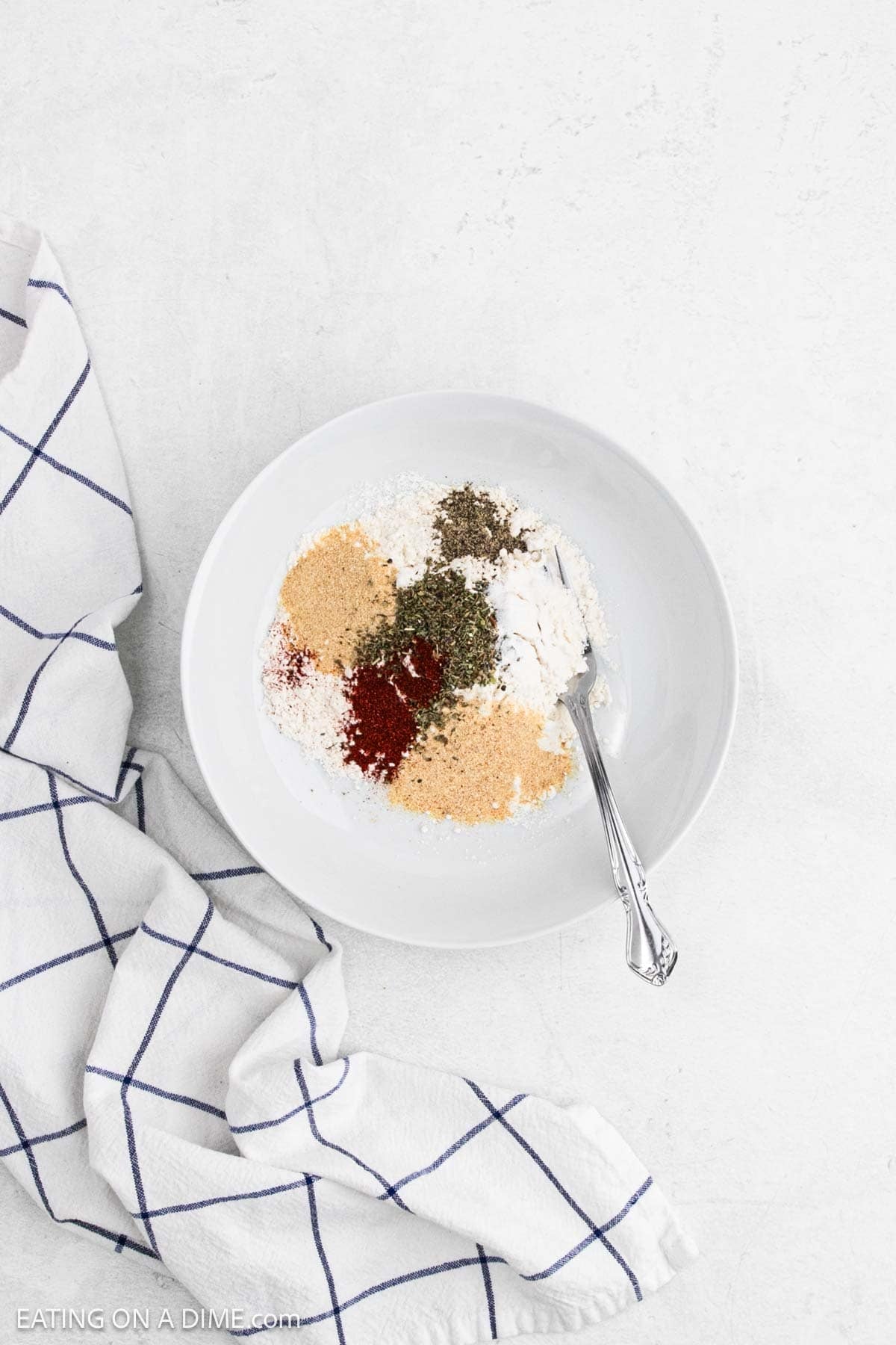 Combining spices with flour in a bowl.