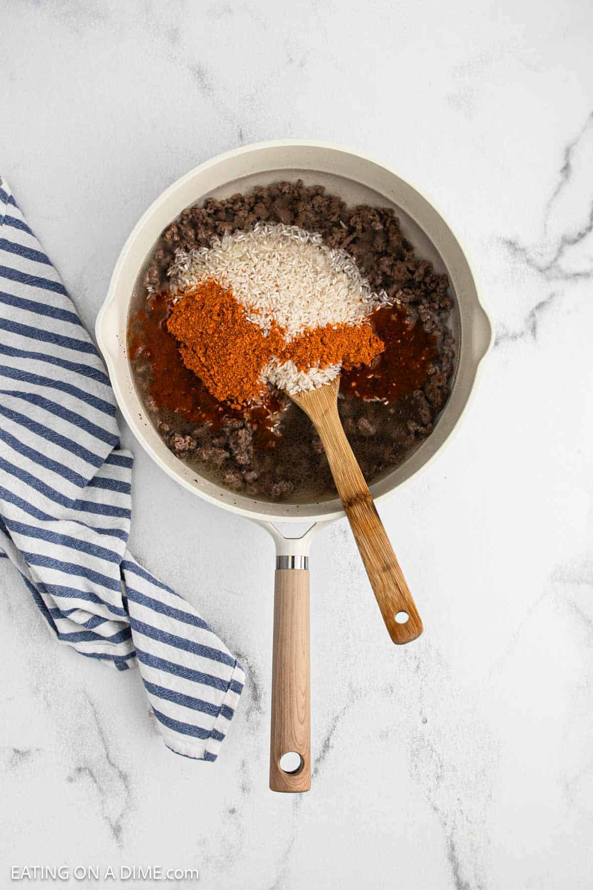 Rice, salsa, water, and taco seasoning added to the skillet with the cooked ground beef.