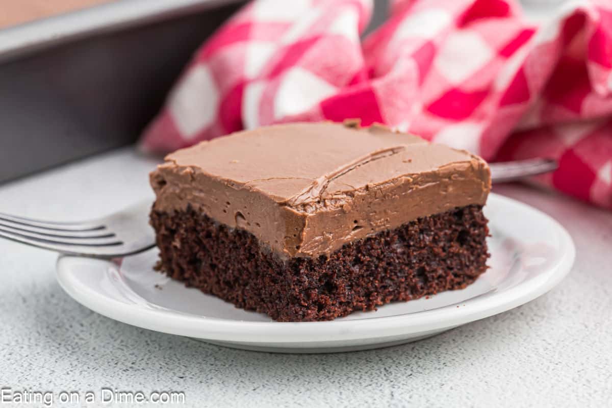 A slice of chocolate sheet cake with chocolate frosting on a plate. 
