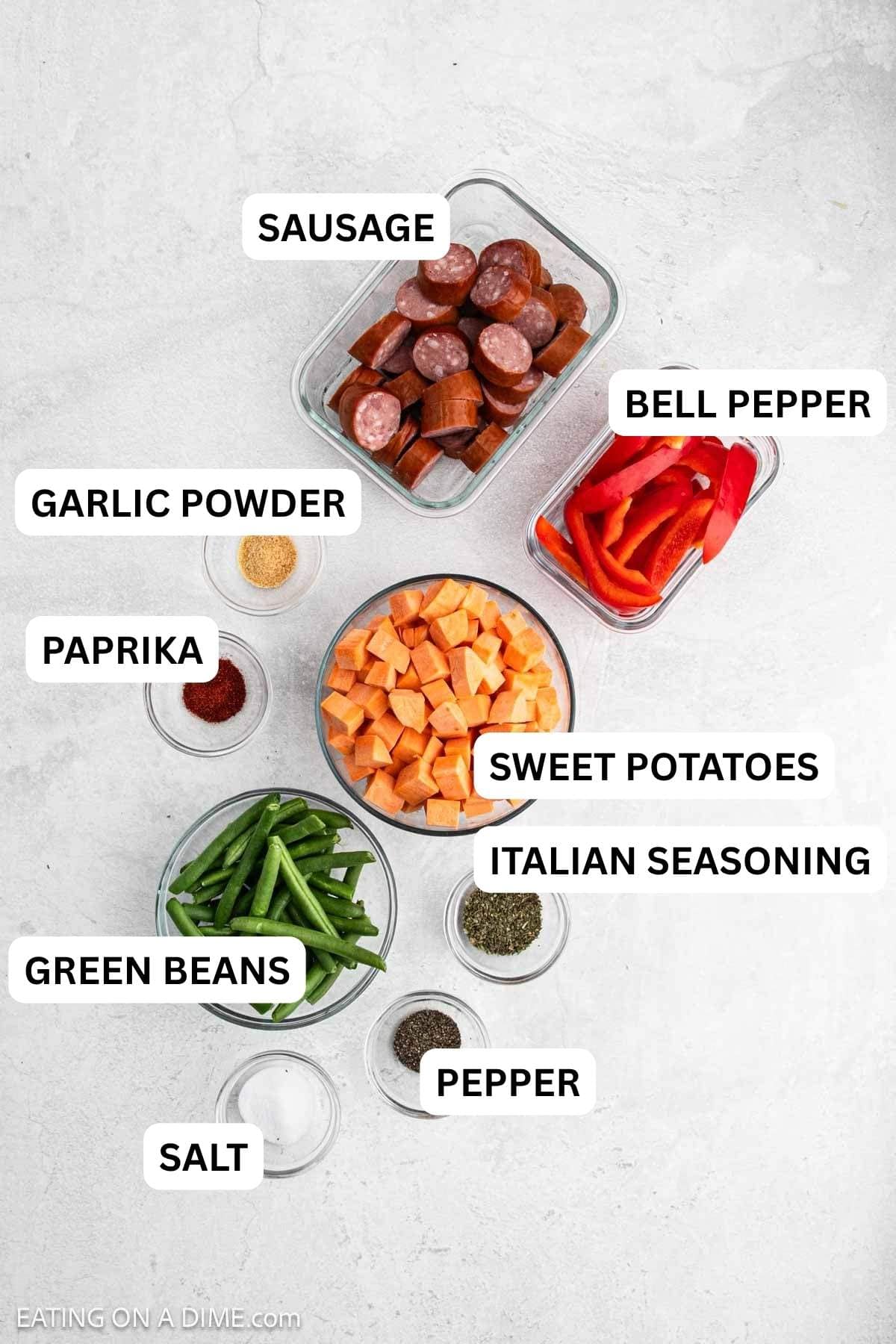 Ingredients needed to make this recipe which includes sweet potatoes, green beans, bell peppers, sausage, and spices.