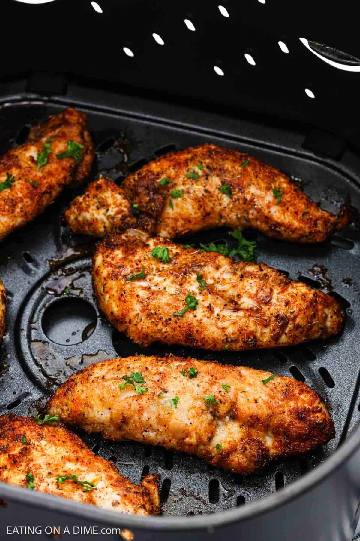Cooked chicken tenders in the air fryer basket.