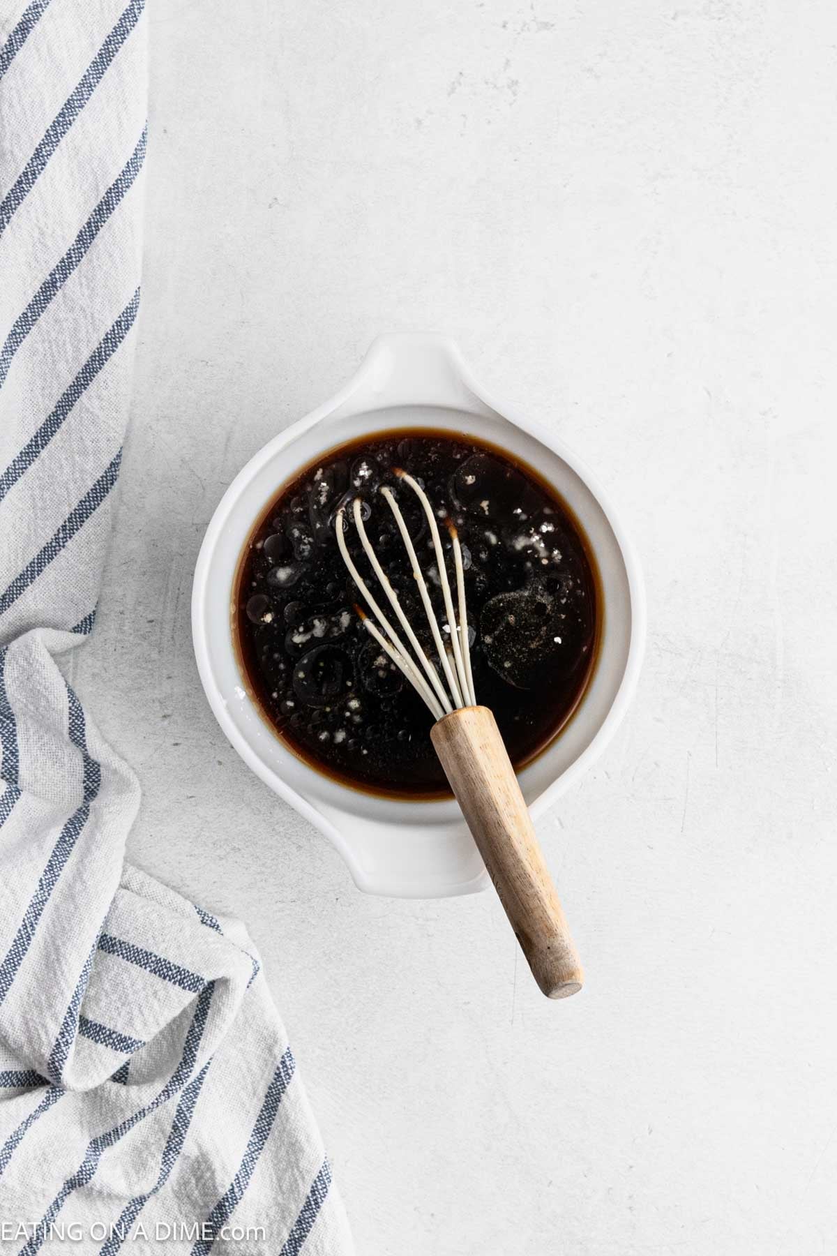 Whisking the sauce ingredients in a bowl with a whisk.