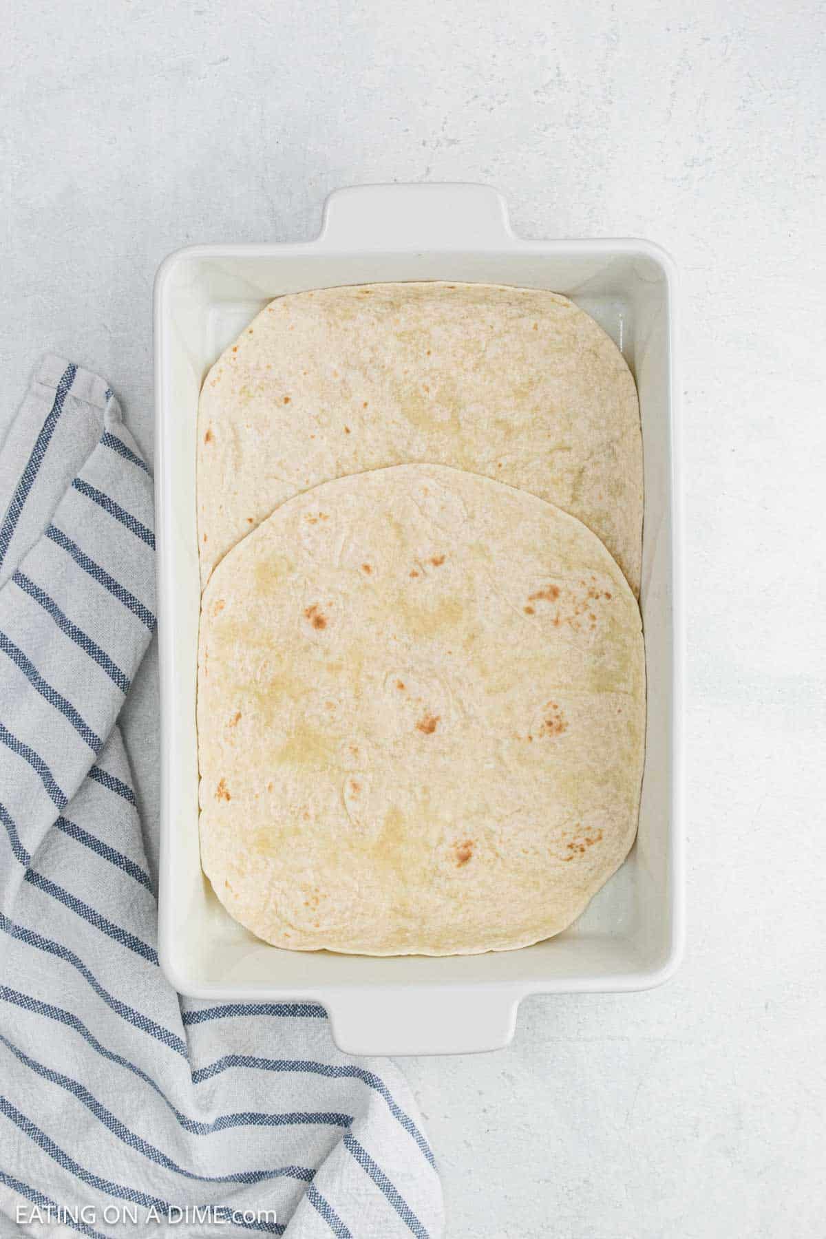 Large flour tortillas in a baking dish.