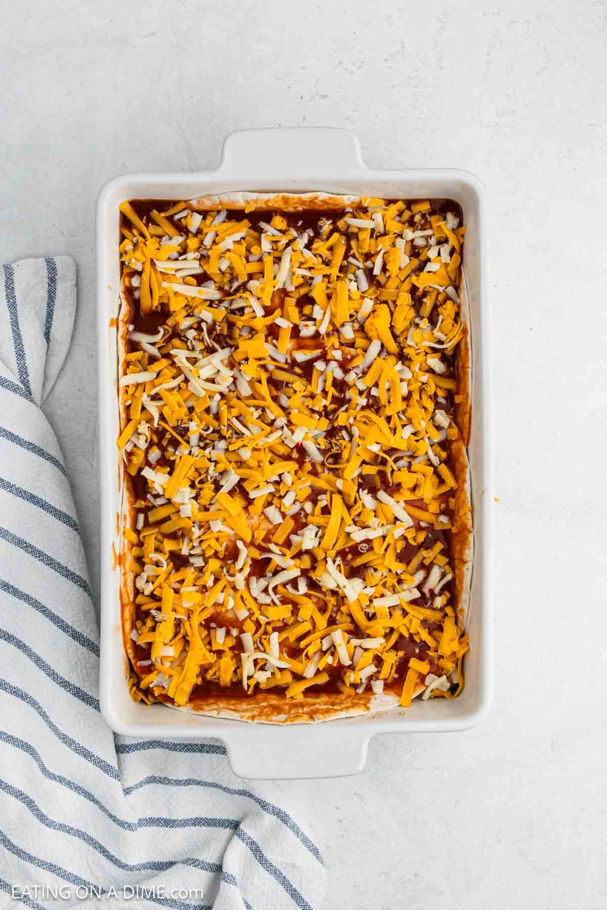 Enchilada sauce poured on the tortillas then topped with shredded cheese.