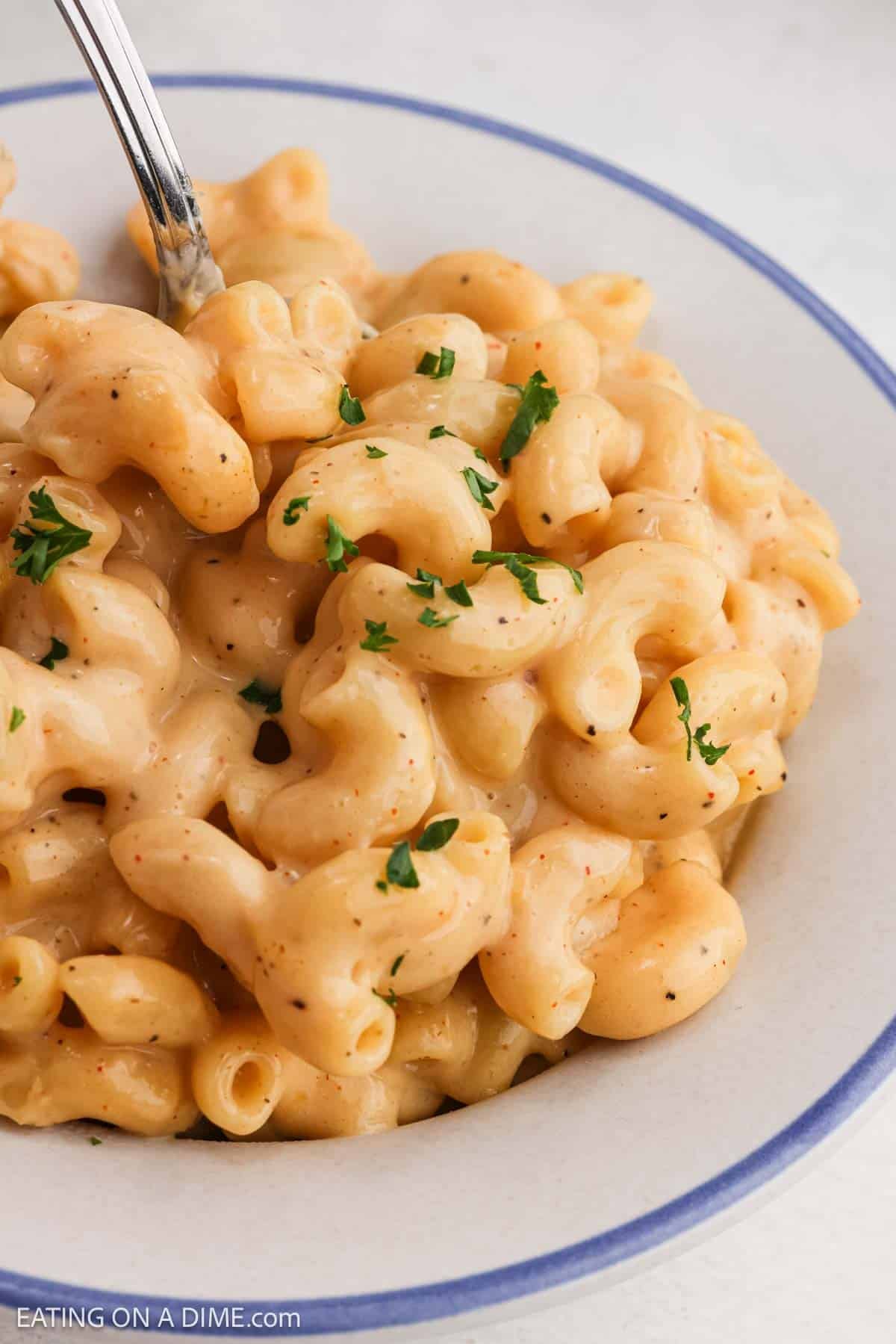 Mac and cheese in a bowl topped with fresh herbs.
