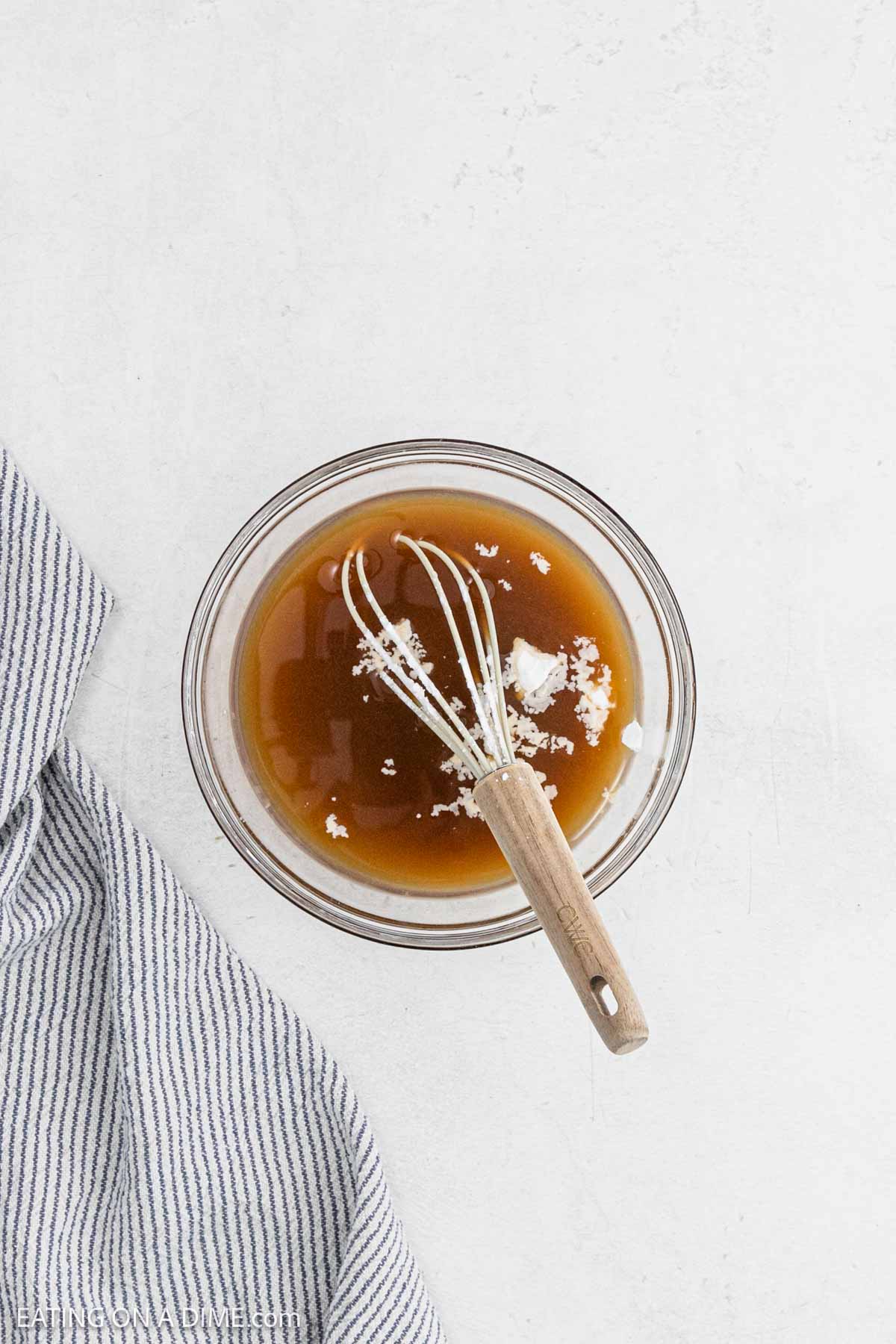 Combining the honey mixture in a bowl with a whisk.