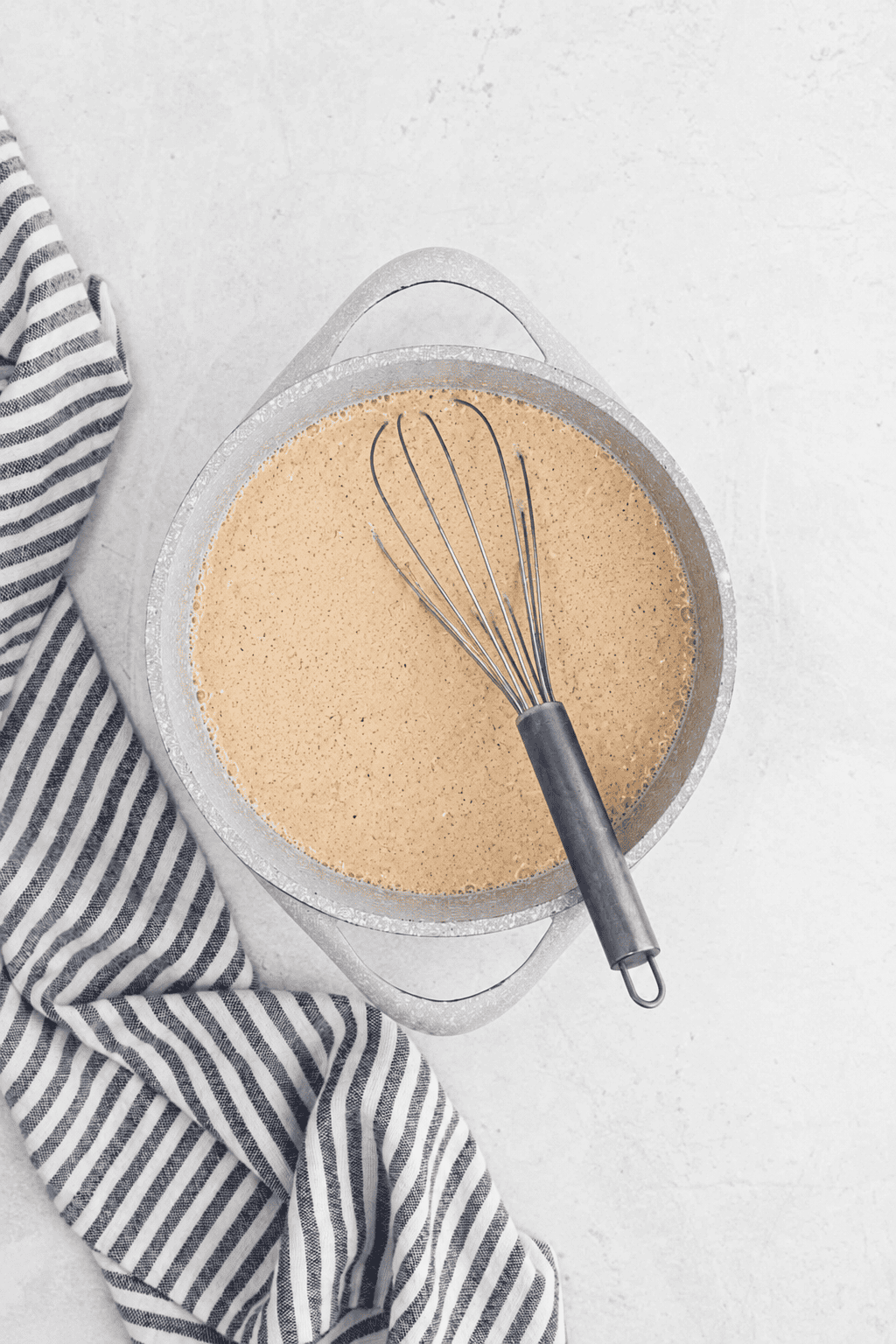Combining the spices into the milk mixture in a large pot with a whisk.