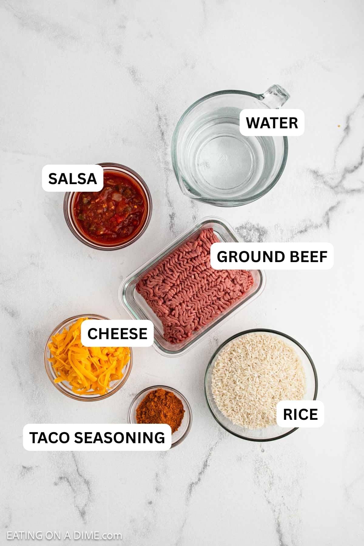 Ingredients needed to make this recipe which includes, shredded cheese, ground beef, rice, taco seasoning, salsa and water.