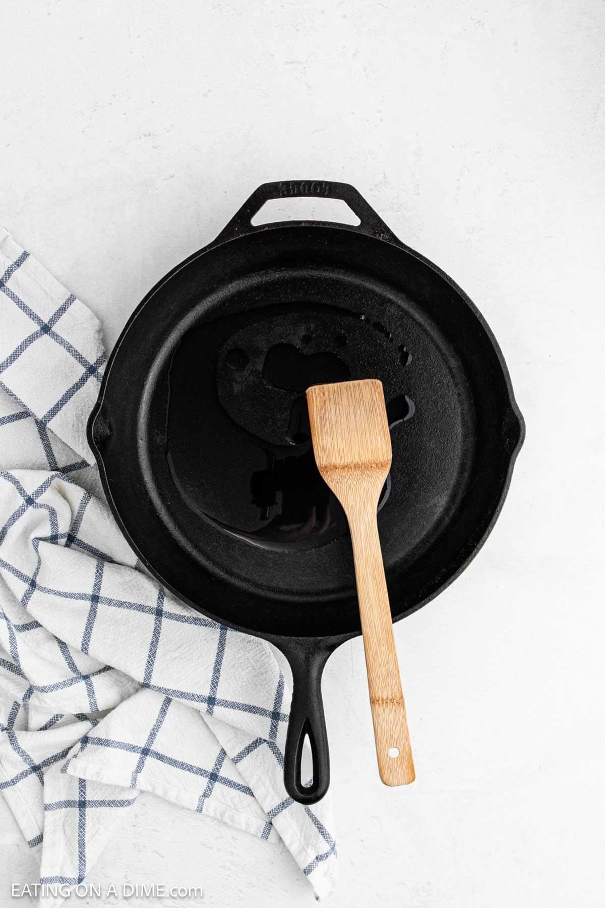 Oil in a cast iron skillet with a wooden spoon.