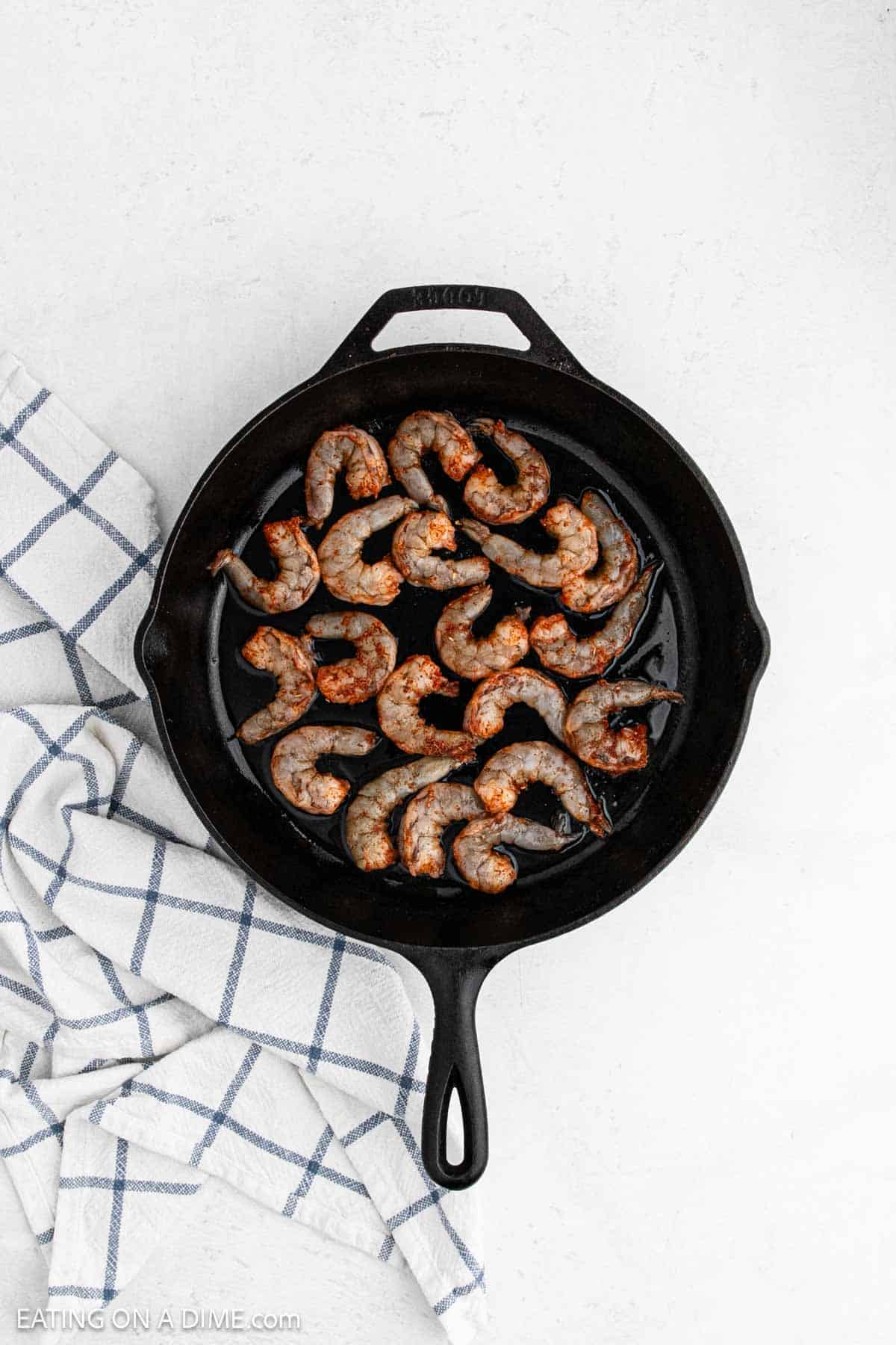 Seasoned raw shrimp in the cast iron skillet.