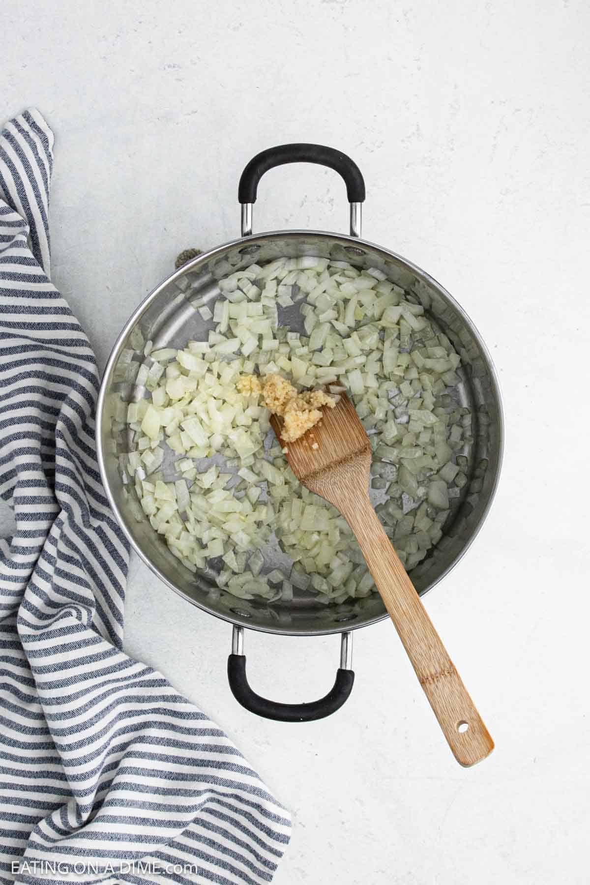 Large pot of cooked diced onions with minced garlic.
