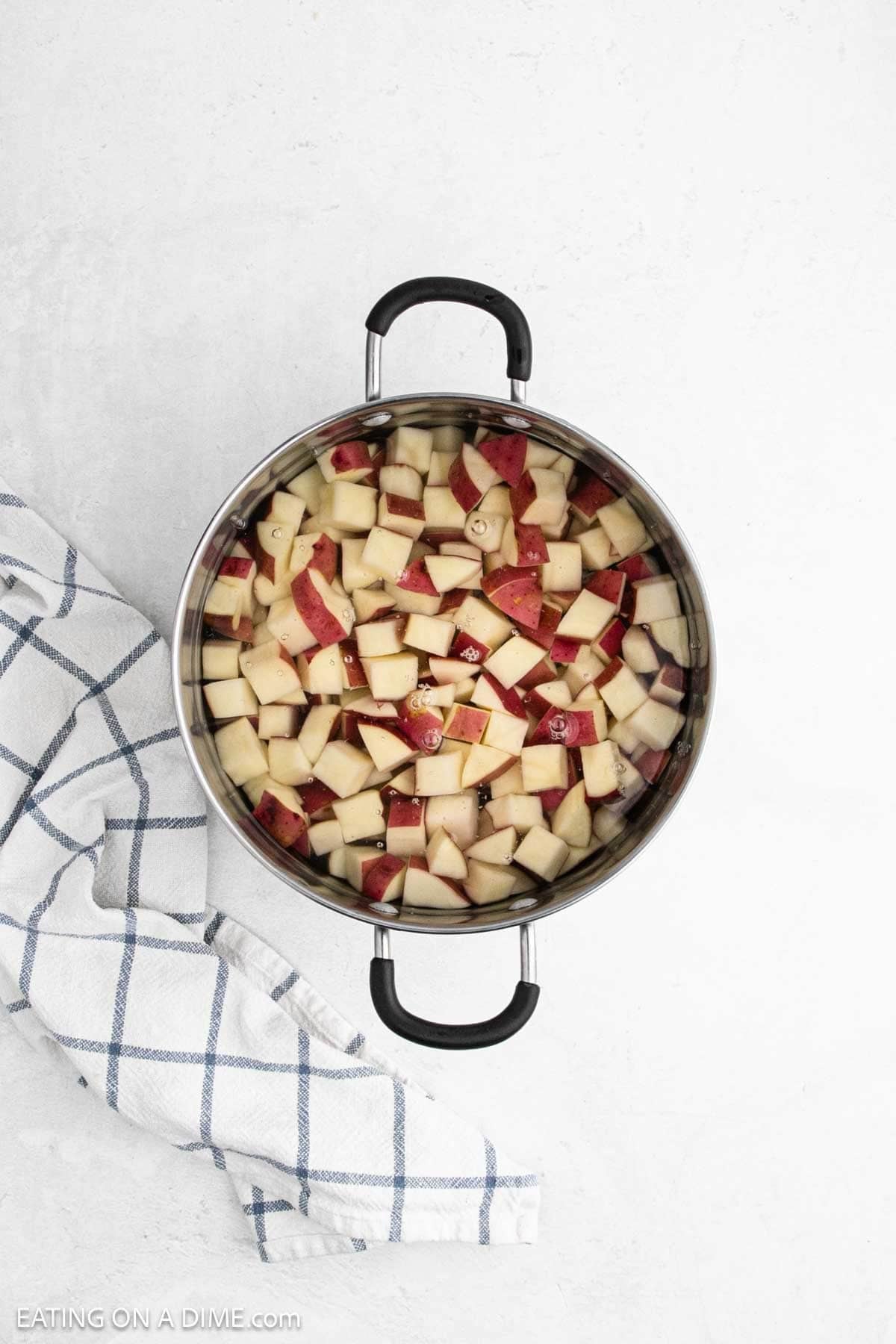 Diced red potatoes in a large pot of water.