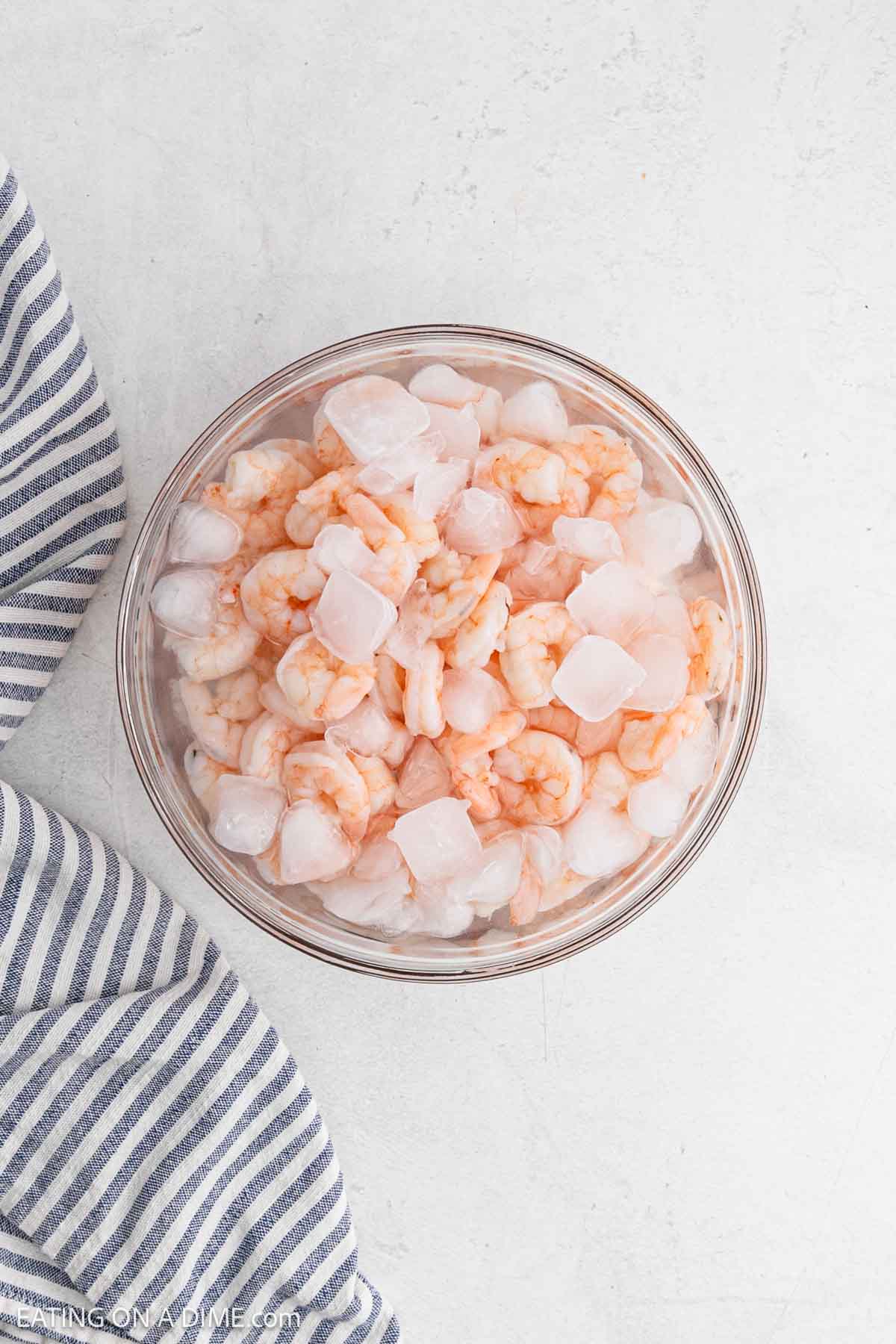Cooked shrimp in a bowl of ice water.