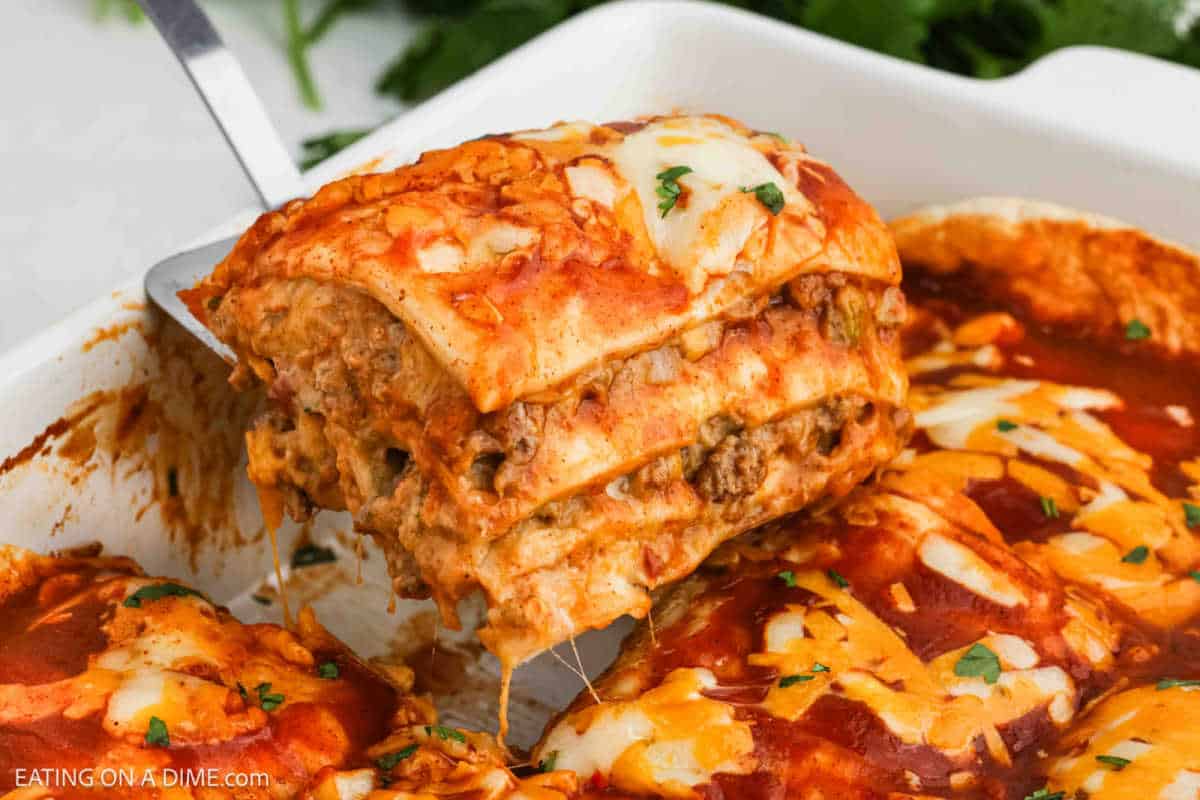 A serving of burrito casserole on a spatula being served out of the baking dish.