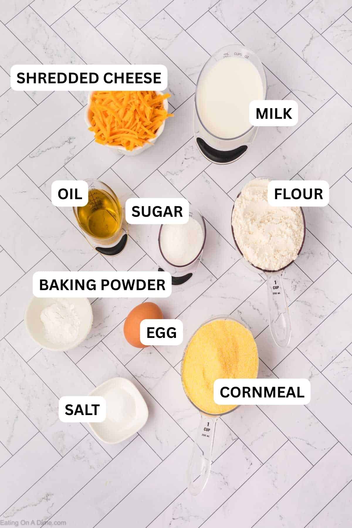Ingredients to make cornbread topping includes cornmeal, flour, sugar, baking powder, milk, oil, egg, and cheese.