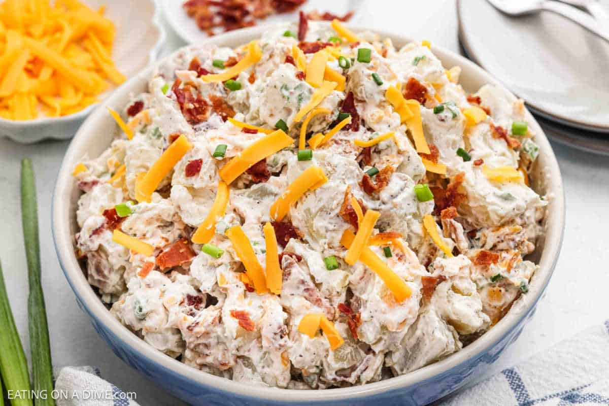 Loaded baked potato salad topped with shredded cheese. 