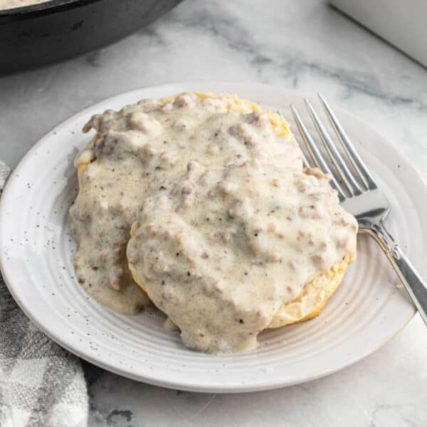 Gravy served over biscuits on a white plate.
