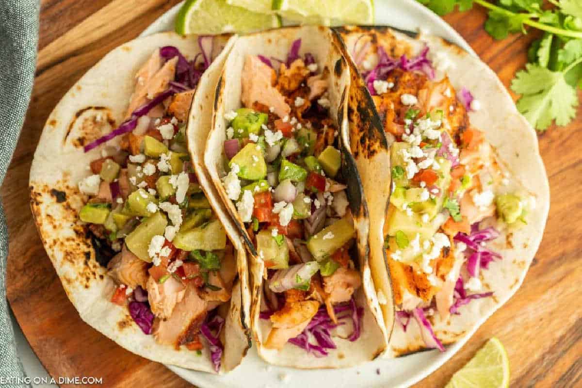 Salmon tacos on a wooden platter.