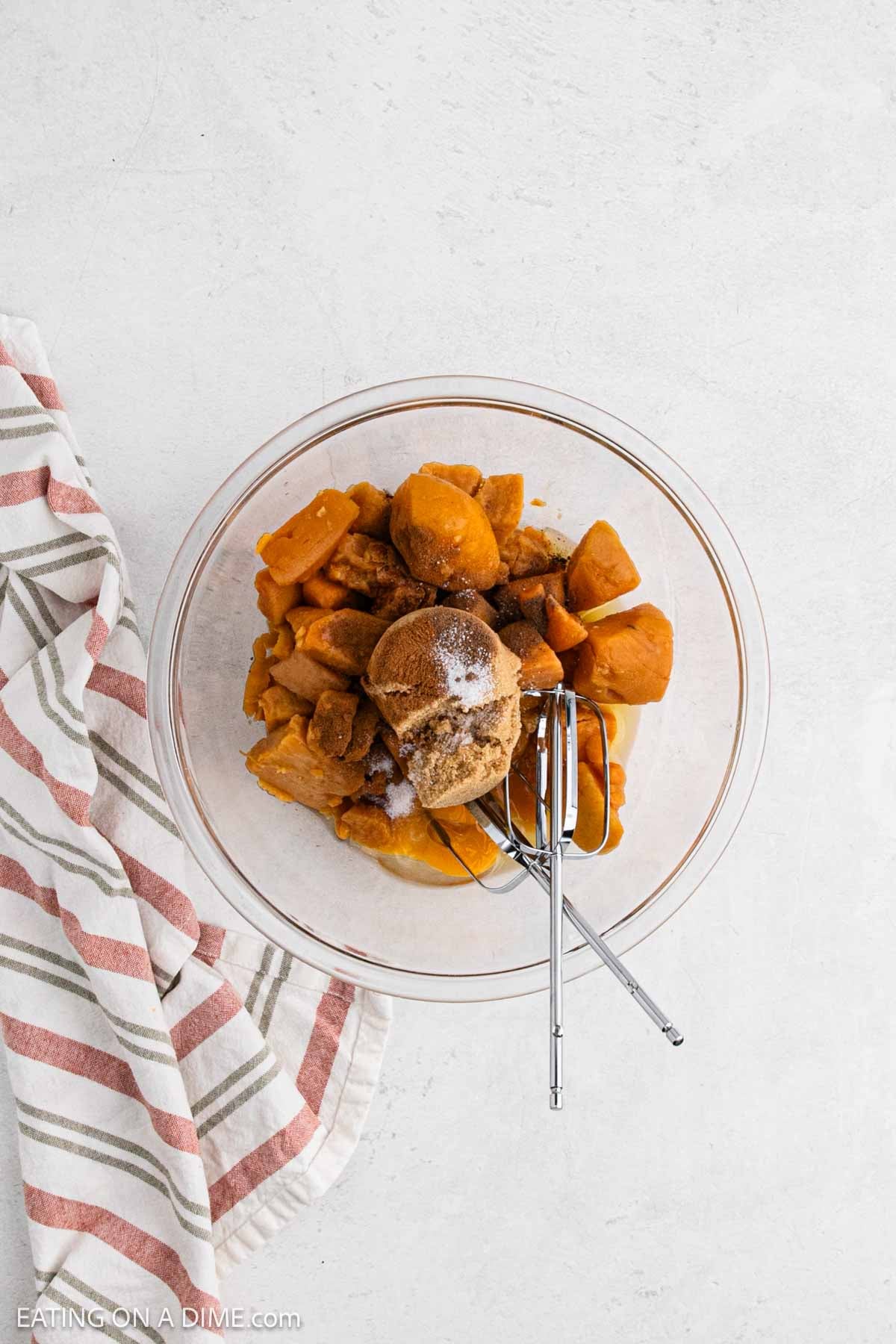 Canned yams and spices added to a bowl.