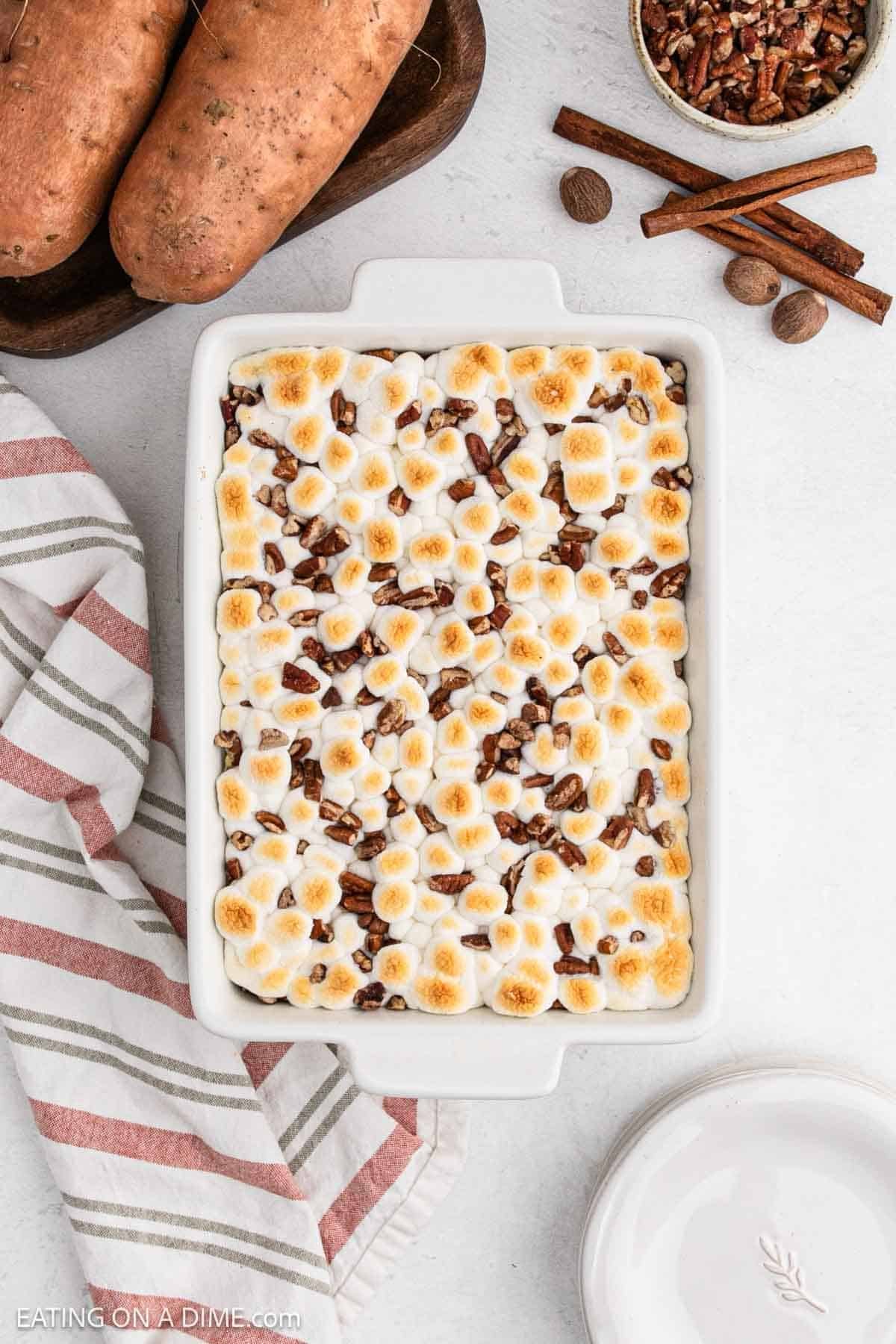 Melted golden brown marshmallows and pecans in a baking dish.