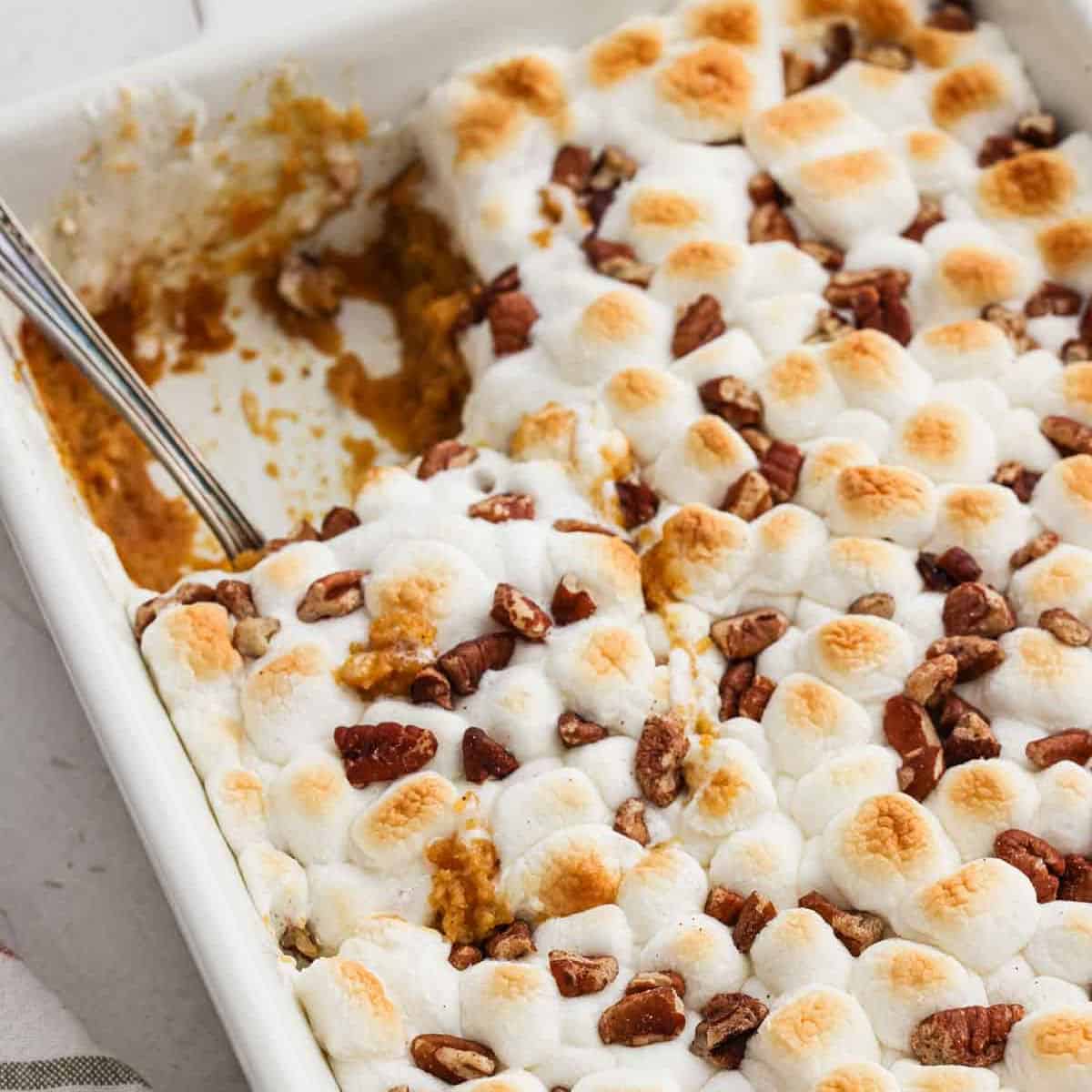 Canned sweet potato casserole topped with golden brown marshmallows in a baking dish.