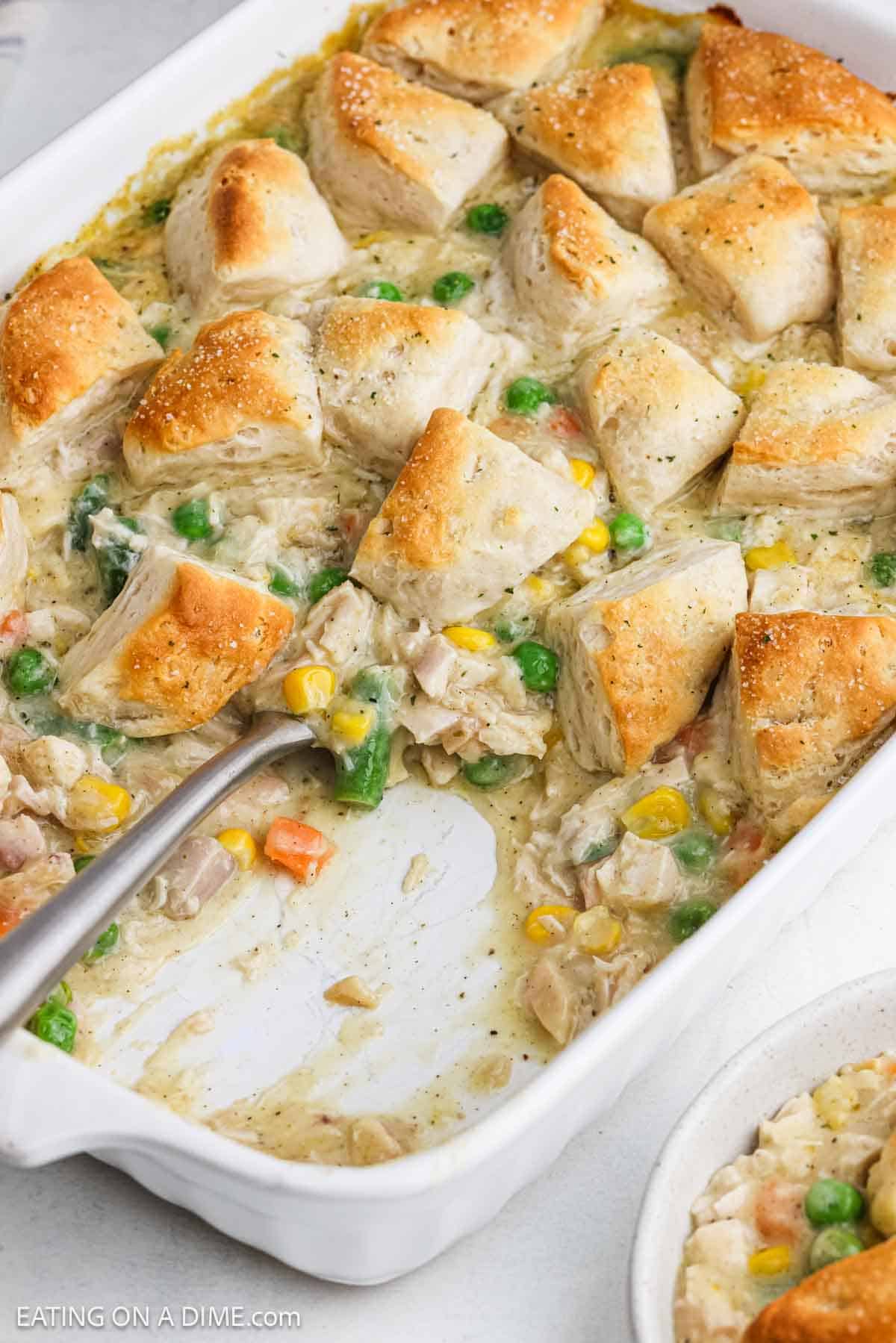 Casserole topped with golden brown biscuit quarters in a baking dish.
