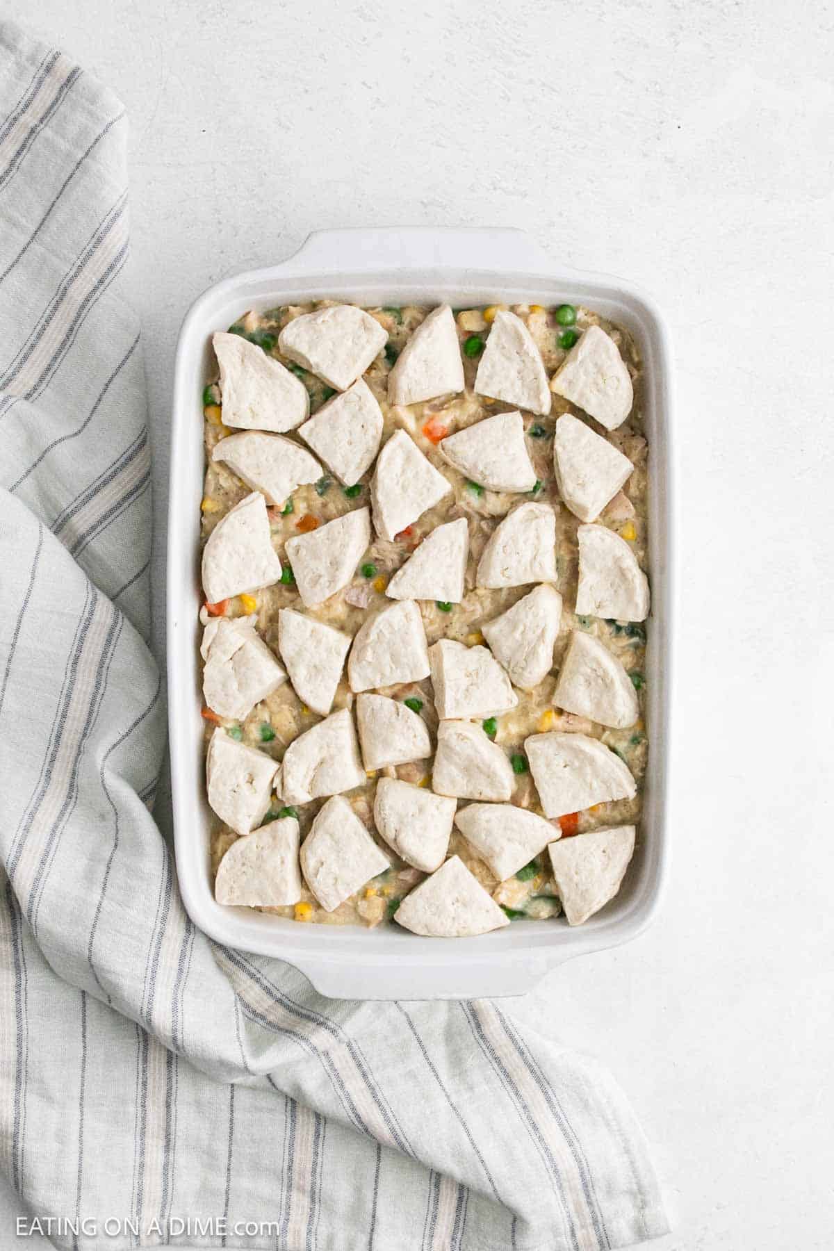Quartered biscuits topped the creamy filling in a baking dish.