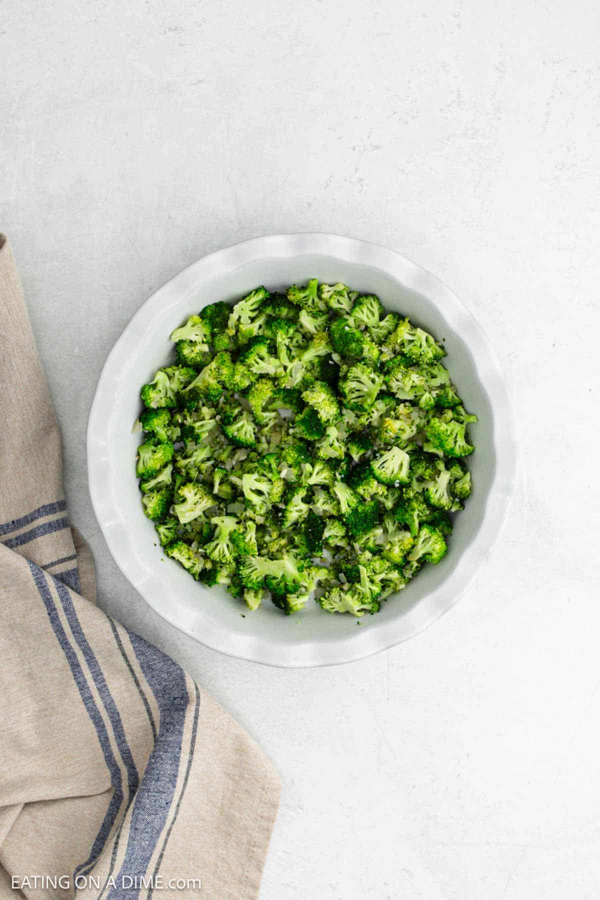 Cooked broccoli in a pie plate.