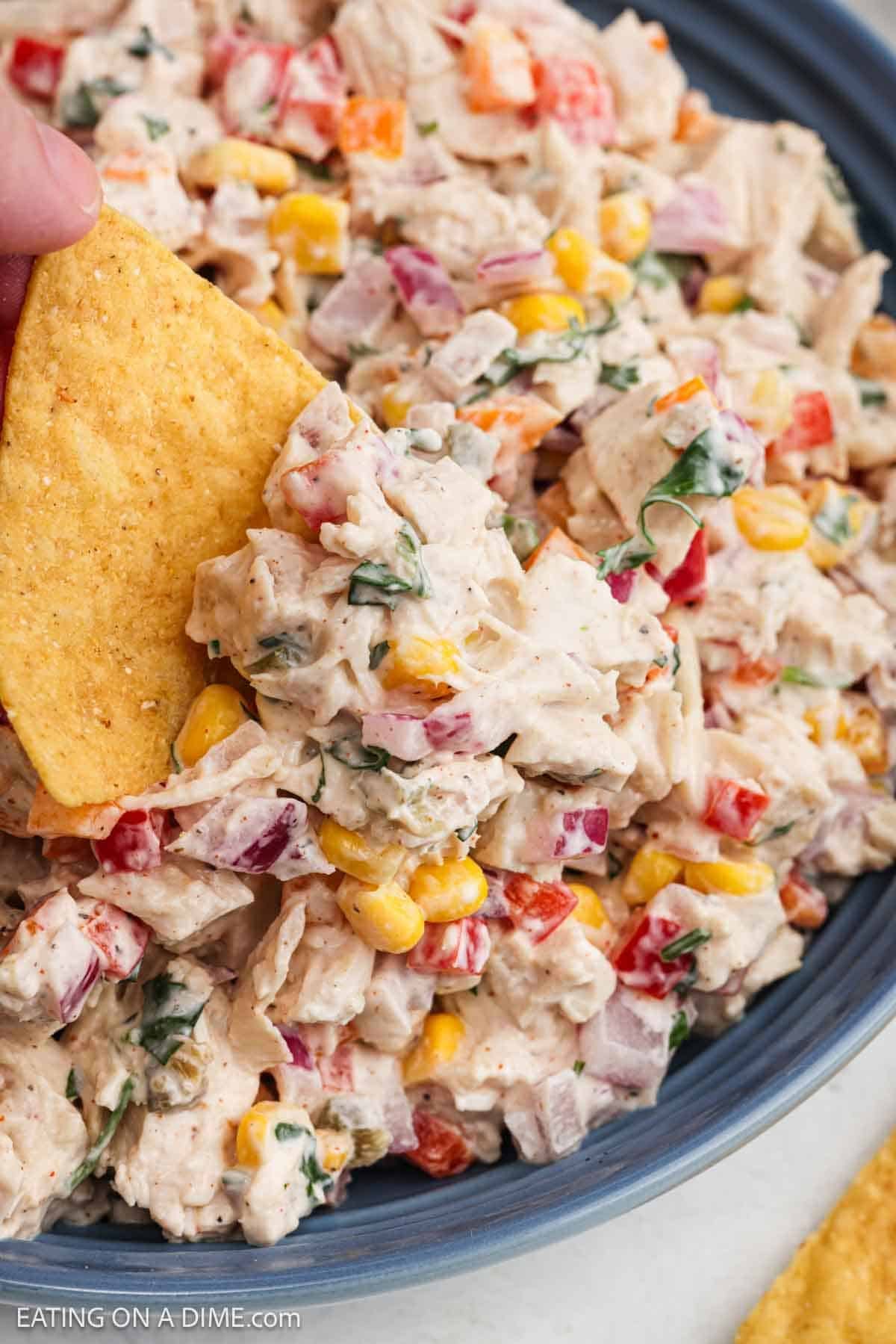 Chip dipping into the salad mixture.