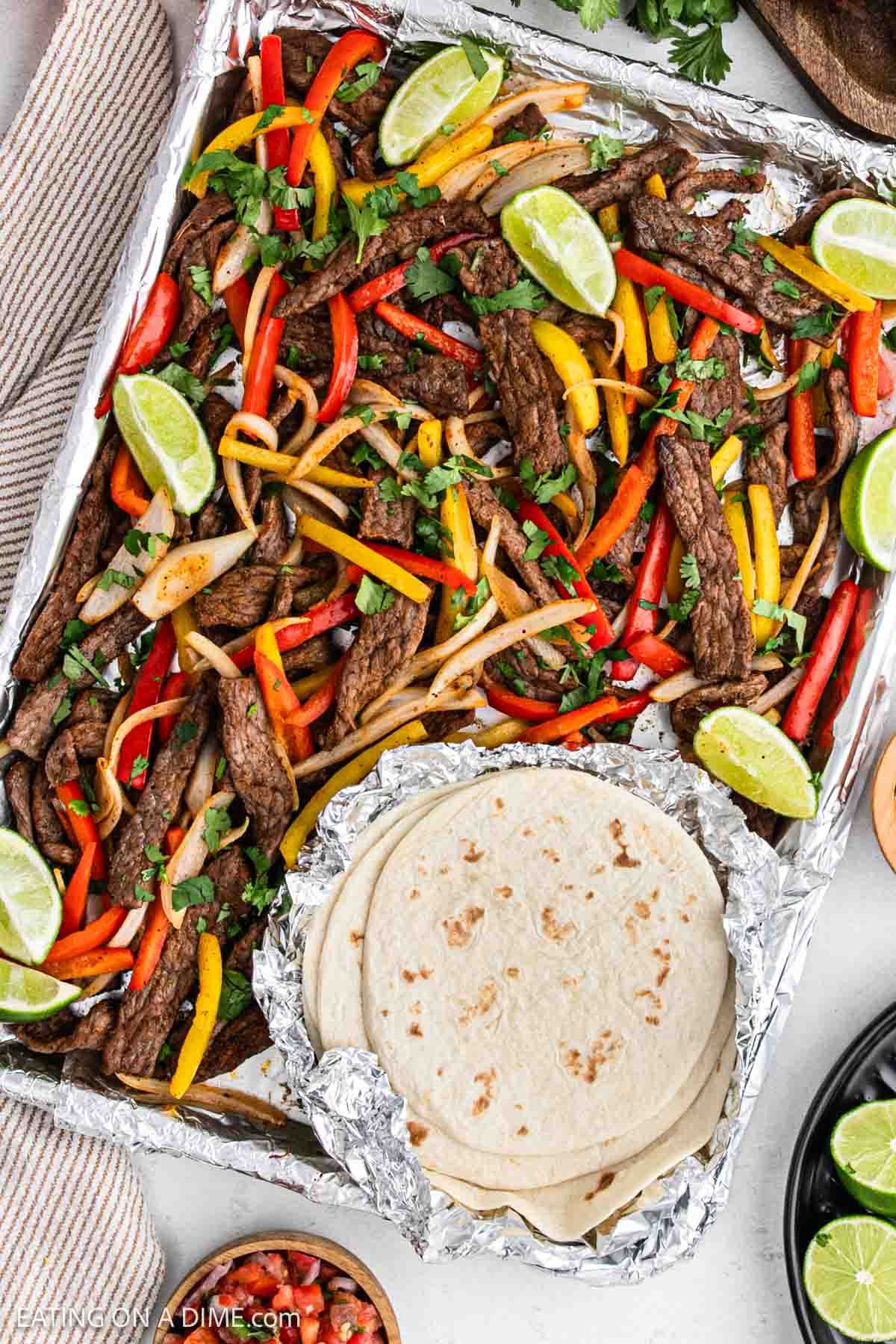 Steak fajita on a foil lined baking sheet.