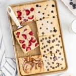 Sheet pan pancakes topped with strawberries, blueberries, chocolate chips and cinnamon swirl.
